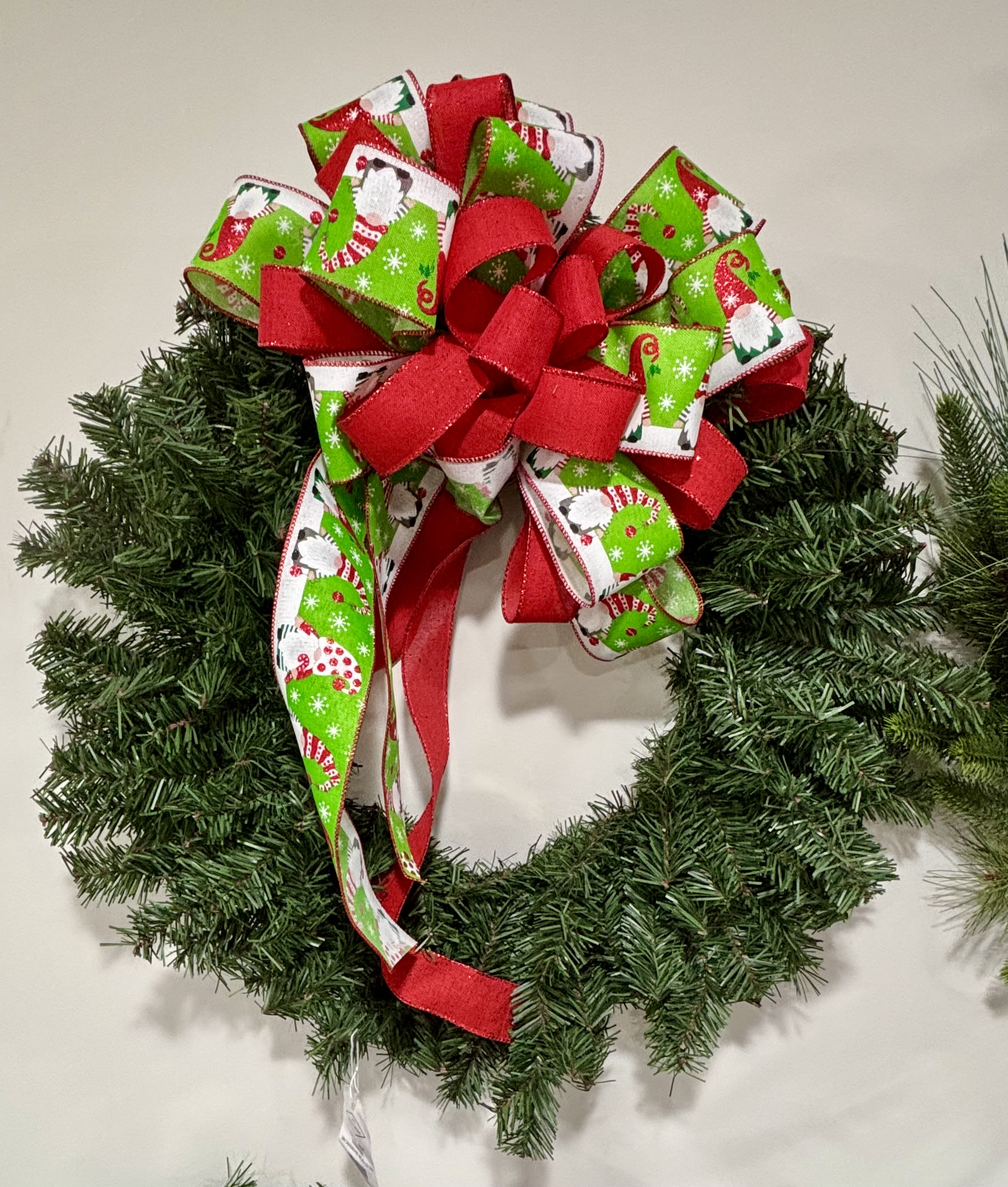 Wreath - Classic Christmas Wreath Bring traditional holiday cheer to your home with this full evergreen wreath topped with a festive multi-layered bow.  (Bow can be the color of your choice) Approx 24&quot; round