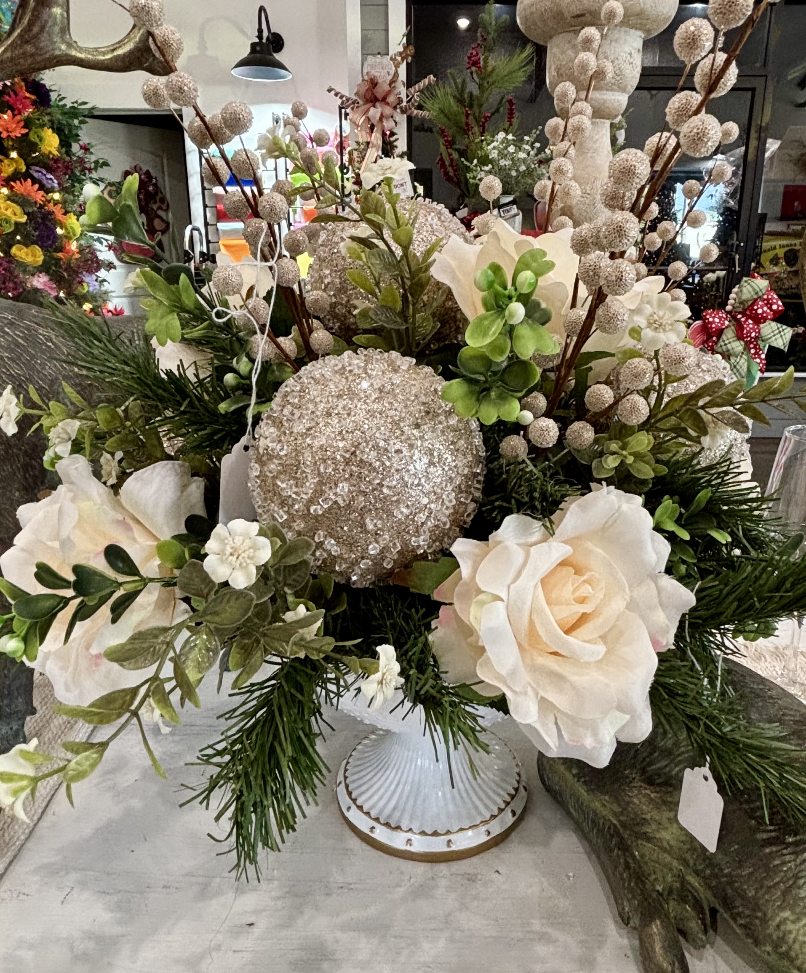 Holiday Centerpiece (Artificial) - Elegant Winter glow centerpiece Soft, sophisticated, and full of winter charm, this stunning arrangement blends creamy ivory florals with sparkling champagne accents for a look that feels both luxurious and timeless.  Approx. 20&quot; tall x 18&quot; wide