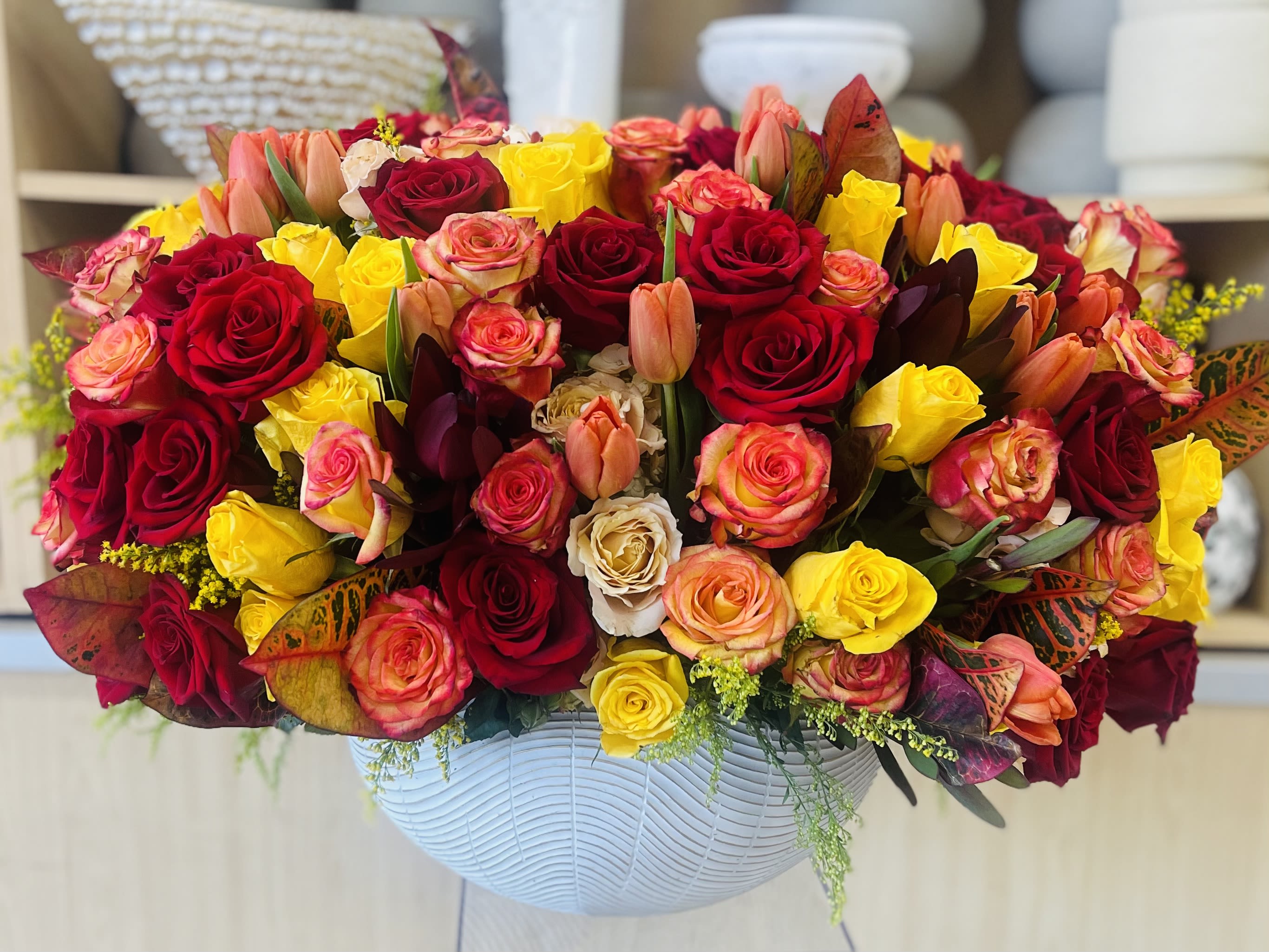 Sunset Bloom  - Golden Harvest Arrangement, a radiant blend of orange and yellow blooms that captures the spirit of festive gatherings. Perfect for Thanksgiving tables, holiday parties, or gifting, this arrangement adds a joyful splash of color and elegance to any space. Each design is handcrafted with fresh, premium flowers and artfully arranged to highlight the beauty of the season.   Some florals are seasonal, if particular flower will not be available due to season, we will substitute for similar flower, composition, color pallet and value of the arrangements as closely as possible. All effort to create a floral arrangement as close to the photo shown, the actual arrangement may vary slightly in its appearance from the photo shown. If you have any questions about your order, we welcome you to call us in or email   