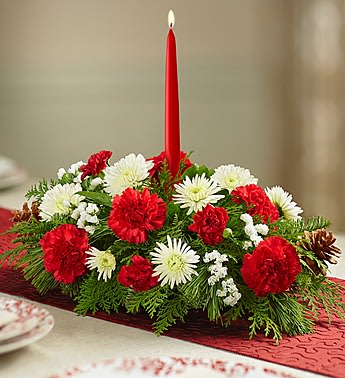 90669 TRADITIONAL CHRISTMAS CENTERPIECE - •Centerpiece arrangement with red roses, carnations and mini carnations; white Asiatic lilies, cushion poms, button poms and statice; assorted greenery; accented with pinecones