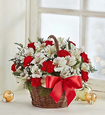 FIELDS OF EUROPE CHRISTMAS BASKET - •Hand-crafted arrangement with red roses and mini carnations; white Asiatic lilies and Peruvian lilies (alstroemeria); baby’s breath and assorted greenery