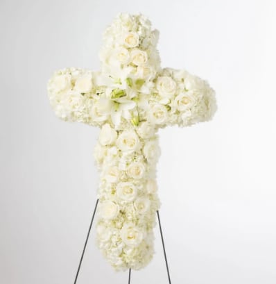 Faith  - An all white tribute, this white cross funeral spray is pure and tranquil. Featuring a variety of white flowers, this elegant easel compliments the beauty of life. 