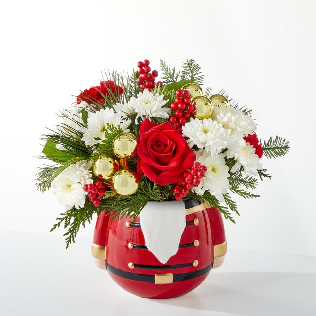 Merry Magic Bouquet (FTD) - Share in the nostalgia of the season with a collectable nutcracker vase effortlessly accented with red and white blooms and fresh holiday pine. Approximately 12 inches wide and 10 inches tall for the Standard size.