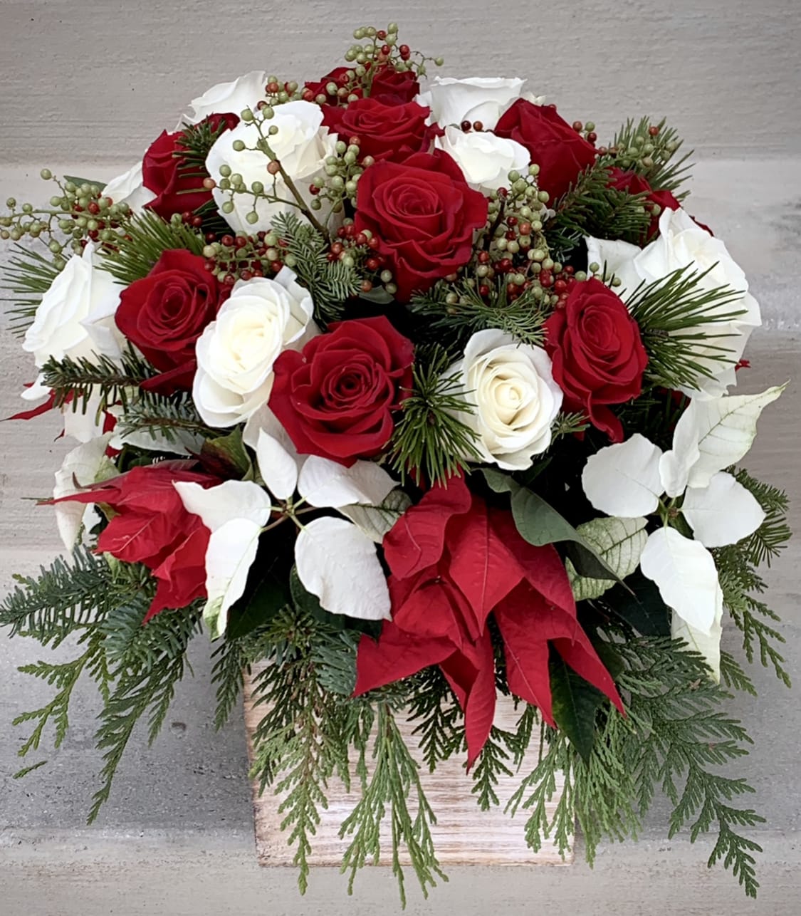 christmas in a wooden box - Mixed white and red blooms such as roses and poinsettia with Christmas greens in a 6&quot; square wooden box. Handwritten message is included. Send the most beautiful flowers for that special someone. Same day delivery available to Tequesta, Jupiter, Palm Beach Gardens and Palm Beach.