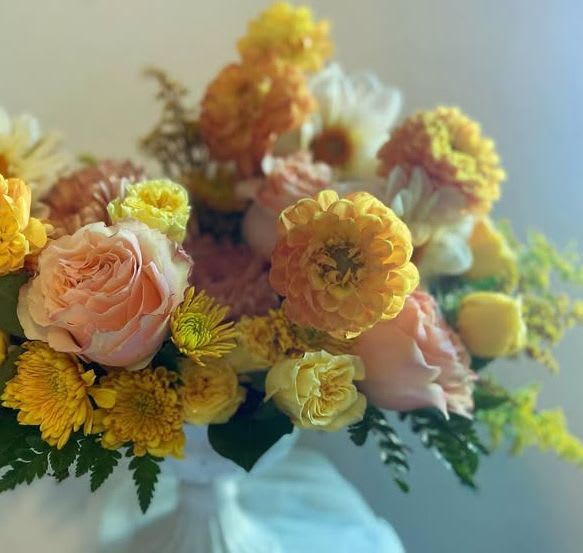 Peaches and Cream  - **Please Note: for this arrangement, blooms will vary depending on in-season availability. Overall vibe/colors will remain constant.**  Introducing our luxurious &quot;Peaches and Cream&quot; floral arrangement, a stunning display that embodies elegance and sophistication. This exquisite centerpiece features a harmonious blend of soft peach and creamy white blooms, artfully arranged to create a serene and inviting atmosphere. Delicate peach roses, lush dahlia, and elegant seasonal floral in varying shades of peach and whites complement each other beautifully. Each flower is carefully selected for its quality and freshness, ensuring a long-lasting and captivating arrangement. Nestled among the blooms are lush greenery and delicate foliage, enhancing the overall texture and depth of the design. This arrangement is perfect for Mother’s Day, showing love and thoughtfulness, events, weddings, or as a luxurious gift for someone special.  Presented in a modern compote vase, our &quot;Peaches and Cream&quot; arrangement is not just your typical bouquet; it's a statement piece that will elevate any space with its timeless charm and beauty.   Indulge in the elegance of this floral masterpiece and let it bring warmth and joy to your home or event.