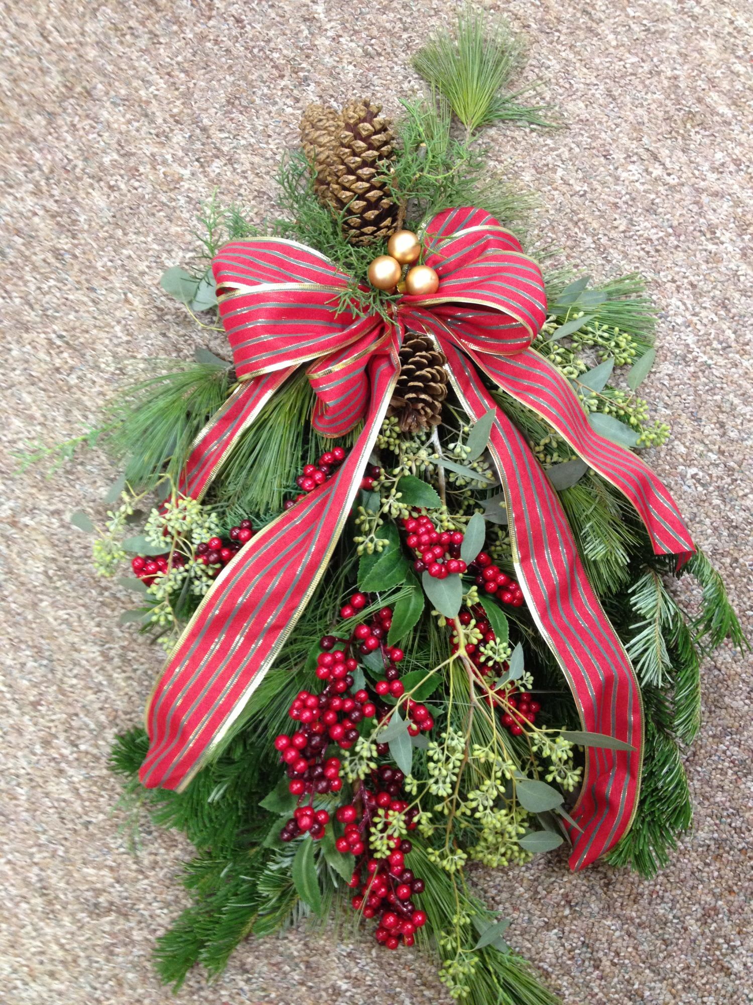 Holiday Door Swag - A fragrant mix of evergreens along with pine cones, ribbon and berries will add a festive touch to the door. The 24&quot; long swag comes ready to hang with a looped wire at the back. You can request red and green, blue and green or neutral in the notes section of your order.