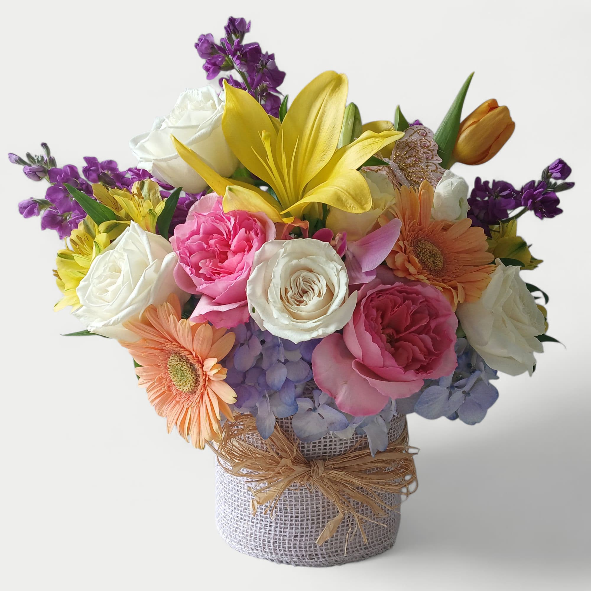 Watercolor Blossoms Designer's Choice - Beautiful pastel watercolor blossoms of the day like roses hydrangeas daisies stock and so much more arranged in modern glass vase wrapped in pretty vanilla jute with raffia bow. Perfect to send for every occasion to show them that you care. Send them happiness today.