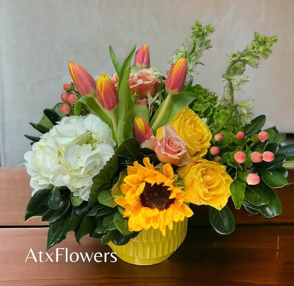  "Sunshine Celebration Bouquet" -  Description: Embrace the warmth and radiance of the sun with our "Sunshine Celebration Bouquet." This vibrant arrangement is a tribute to the joy and positivity that your loved ones bring into your life. Featuring beautiful sunflowers, lush green hydrangeas, elegant roses, cheerful tulips, and more, each bloom embodies the essence of sunshine and happiness.  Whether you're celebrating a special occasion or simply want to brighten someone's day, the "Sunshine Celebration Bouquet" is the perfect choice. Let its vibrant colors and lively blooms spread warmth and joy, reminding your loved ones of the sunshine they bring into your life every day.