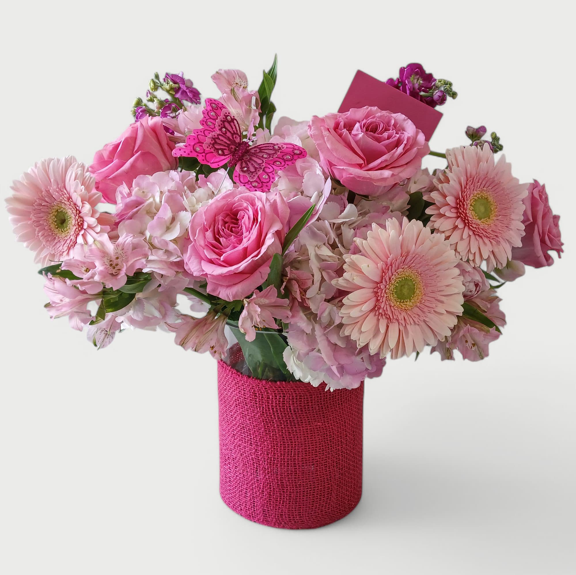 I Love You Pink Rose Bouquet - All pink blossoms bouquet filled with roses hydrangeas daisies and more arranged in a tall glass vase wrapped in pretty pink jute ribbon. Gorgeous and adorned with a sweet pink butterfly. Show her how much you love her.