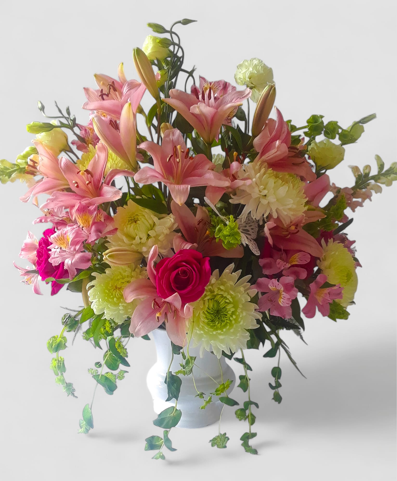 Sympathy Arrangement Designer's Choice - Send this beautiful tall sympathy arrangement filled with a lovely mix of soft pastel blossoms of the day roses hydrangeas orchids lilies and more arranged in a tall modern white vessel vase. Perfect to send to the service to show them how much you care. Always made extra special and unique each time. Send them your deepest condolences.