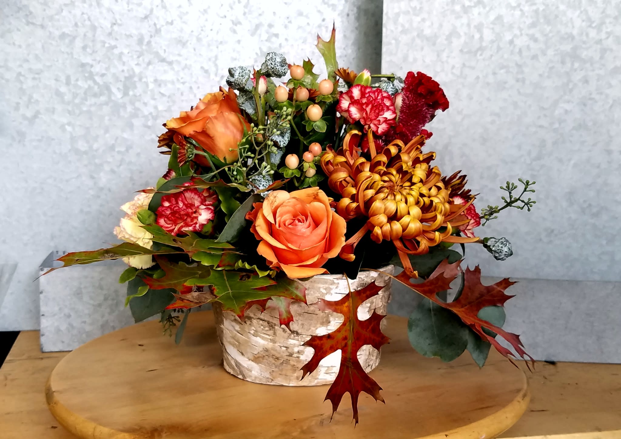 Autumn Leaves Centerpiece - This festive centerpiece celebrates all the rich, warm, tones of fall.  Roses, red-rover mums, celosia, pom-poms, and a lush chrysanthemum burst out of a birch wrapped container.  Makes a wonderful focal point for any tablescape.  6&quot; diameter container, overall dimensions vary through standard, deluxe, premium.