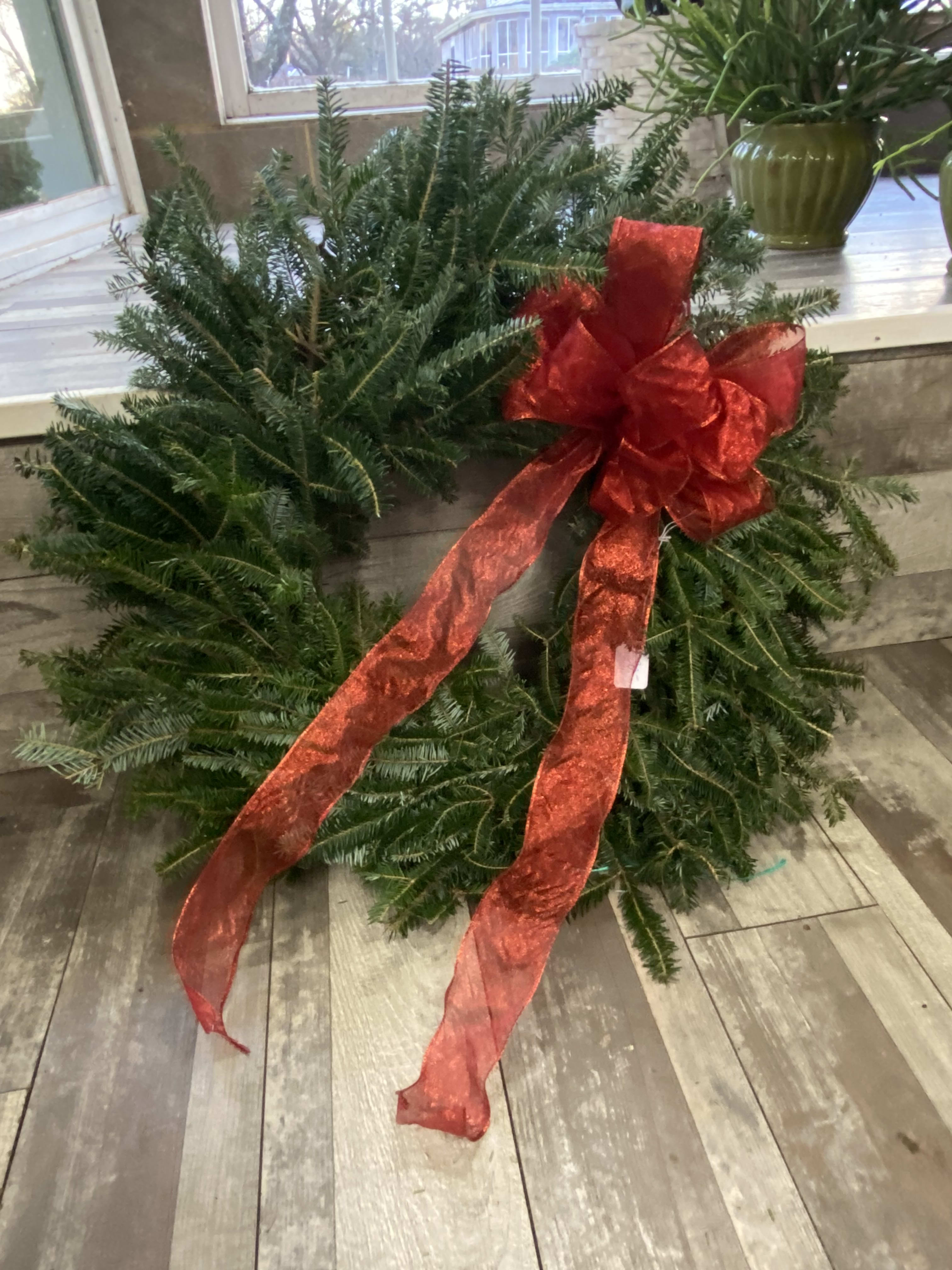 Wreath with bow - An evergreen wreath with a beautiful ref bow. Let us know if you'd prefer a different color bow.