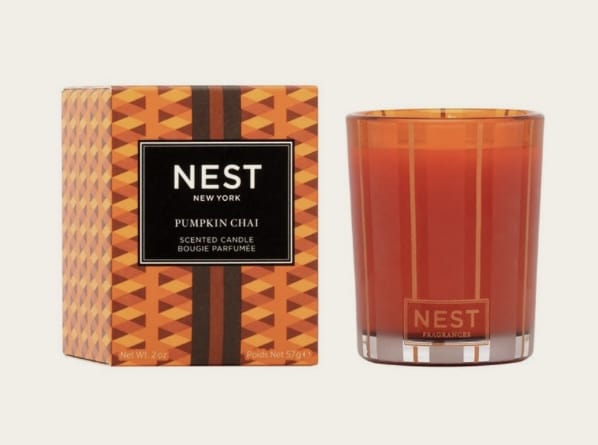 Pumpkin Chai Votive Candle - Create a cozy autumn ambiance with this exquisitely fragranced Votive Candle featuring a blend of wild pumpkin, spicy masala chai, cardamom, ginger, and cinnamon. Orange-tinted wax housed in a glass vessel of the same color with elegant gold and frosted stripes. This exquisitely fragranced candle is meticulously crafted with a proprietary premium wax formulated so the candle burns cleanly and evenly and infuses a room with exceptional scent