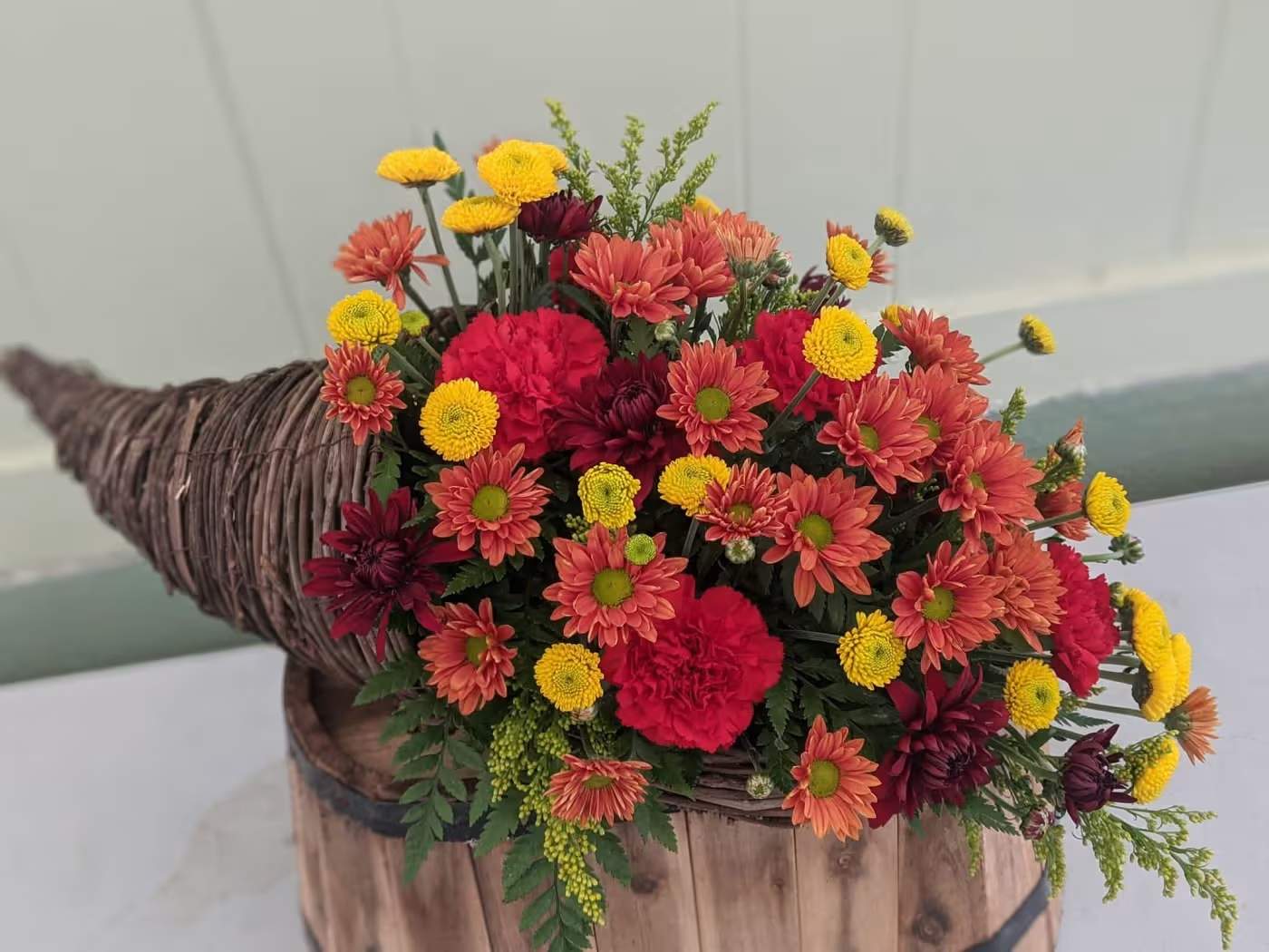 Harvest Grace Cornucopia - Our Harvest Grace Cornucopia features elegant fall florals and natural accents arranged in a rustic horn-of-plenty basket. A timeless piece that adds charm to any table or entryway.