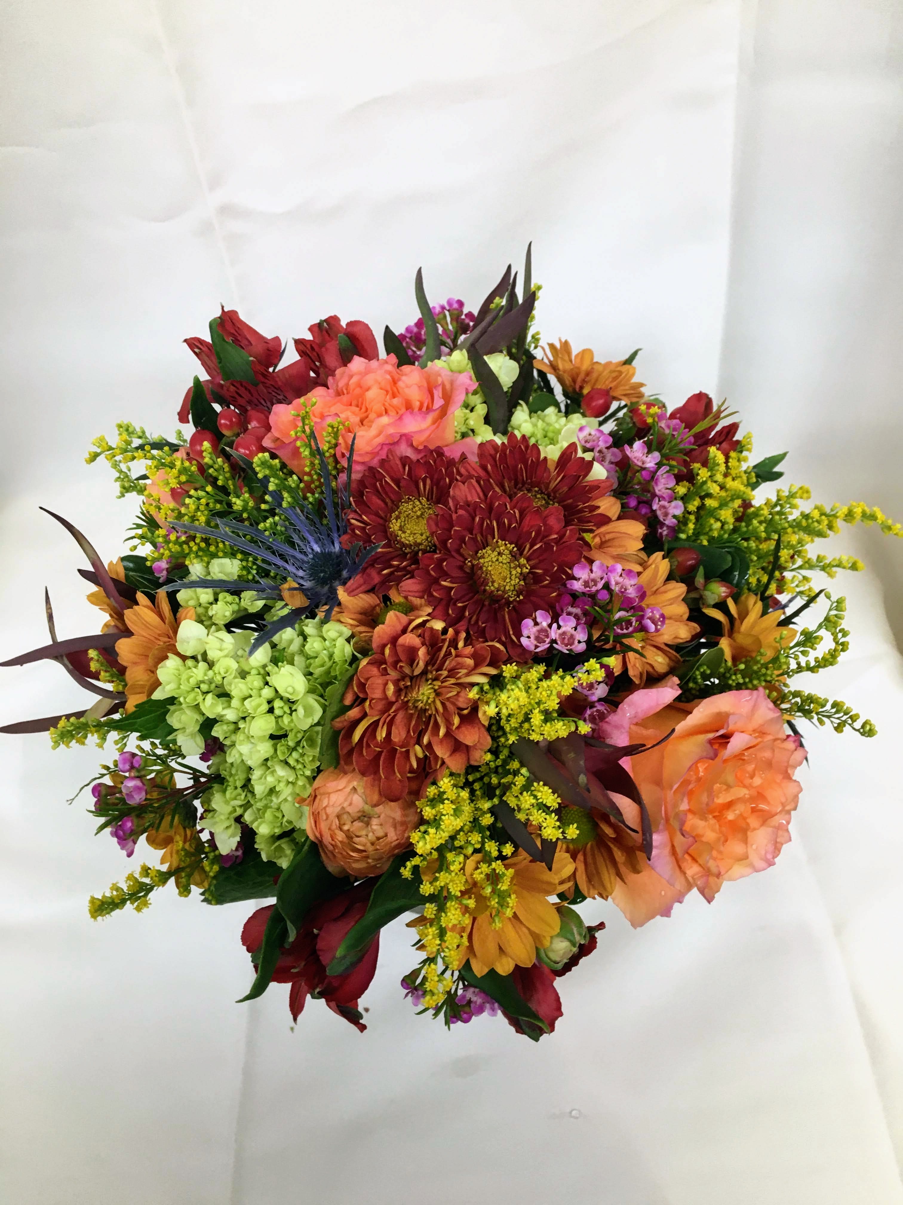 Giving Thanks Centerpiece - A beautiful mixture of fall flowers in a low clear glass vase. A perfect centerpiece for a table that seats 4 - 6 people.