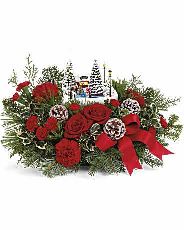Thomas Kincade Oh What Fun Bouquet - Celebrate the holidays with Thomas Kinkade's Oh What Fun arrangement. It includes vibrant red roses, classic red carnations, and miniature red carnations, accented with variegated holly, noble fir, white pine, and cedar. Delivered in Teleflora's charming Thomas Kinkade's Oh What Fun Keepsake, it makes a festive seasonal centerpiece. Approximately 18 1/2 W x 10 3/4 H  