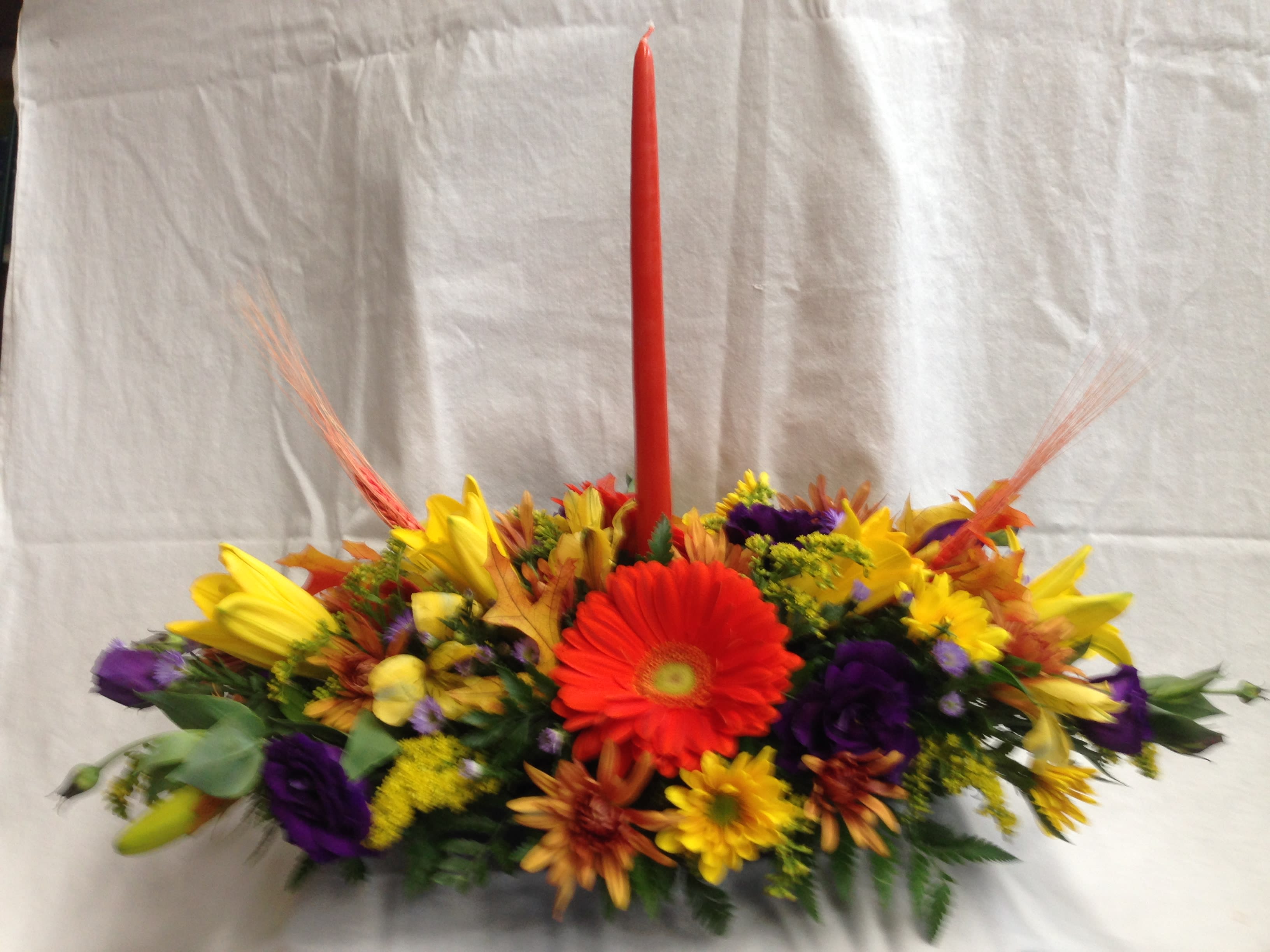 Thanksgiving centerpiece  - Festive centerpiece with candle and fall flowers for the center of the table.