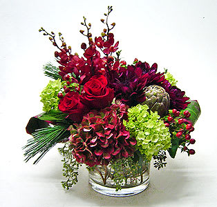 Modern Christmas  - This high end arrangement has a compact style perfect for a gift or a table arrangement. Flowers include all Holland flowers, roses, hydrangea, orchids berries and winter greens. 