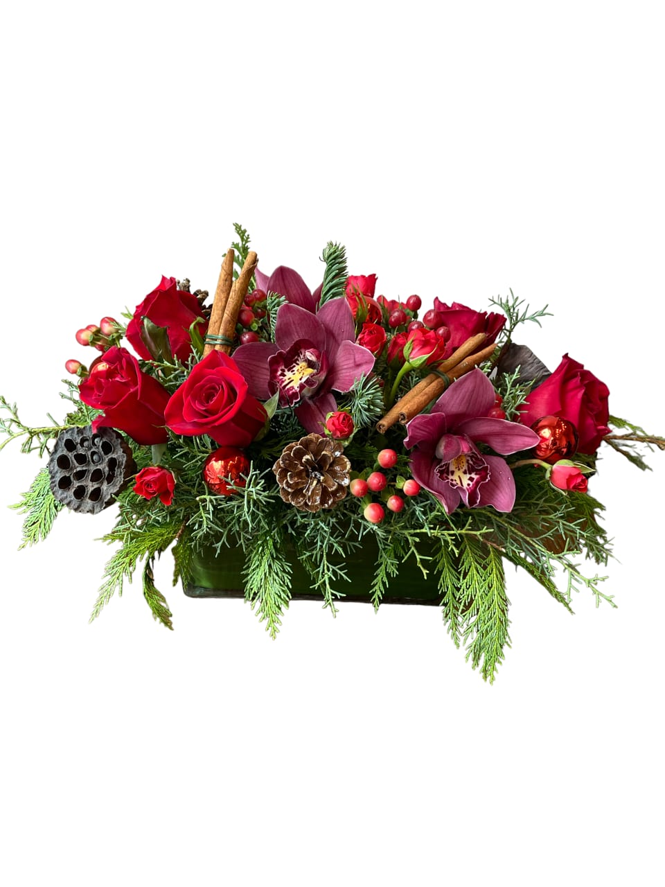 Centerpiece Holiday - Cymbidium orchids, roses, berries and Christmas greens lotus pods designed in a rectangular glass vase.