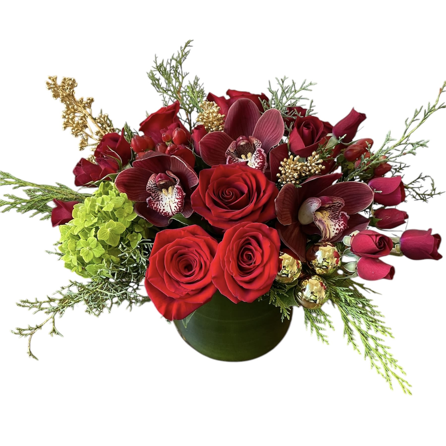 Christmas Cheer  - Red roses, red orchids, red spray roses, green hydrangea, red berries and gold holiday decor. As shown in a glass vase.