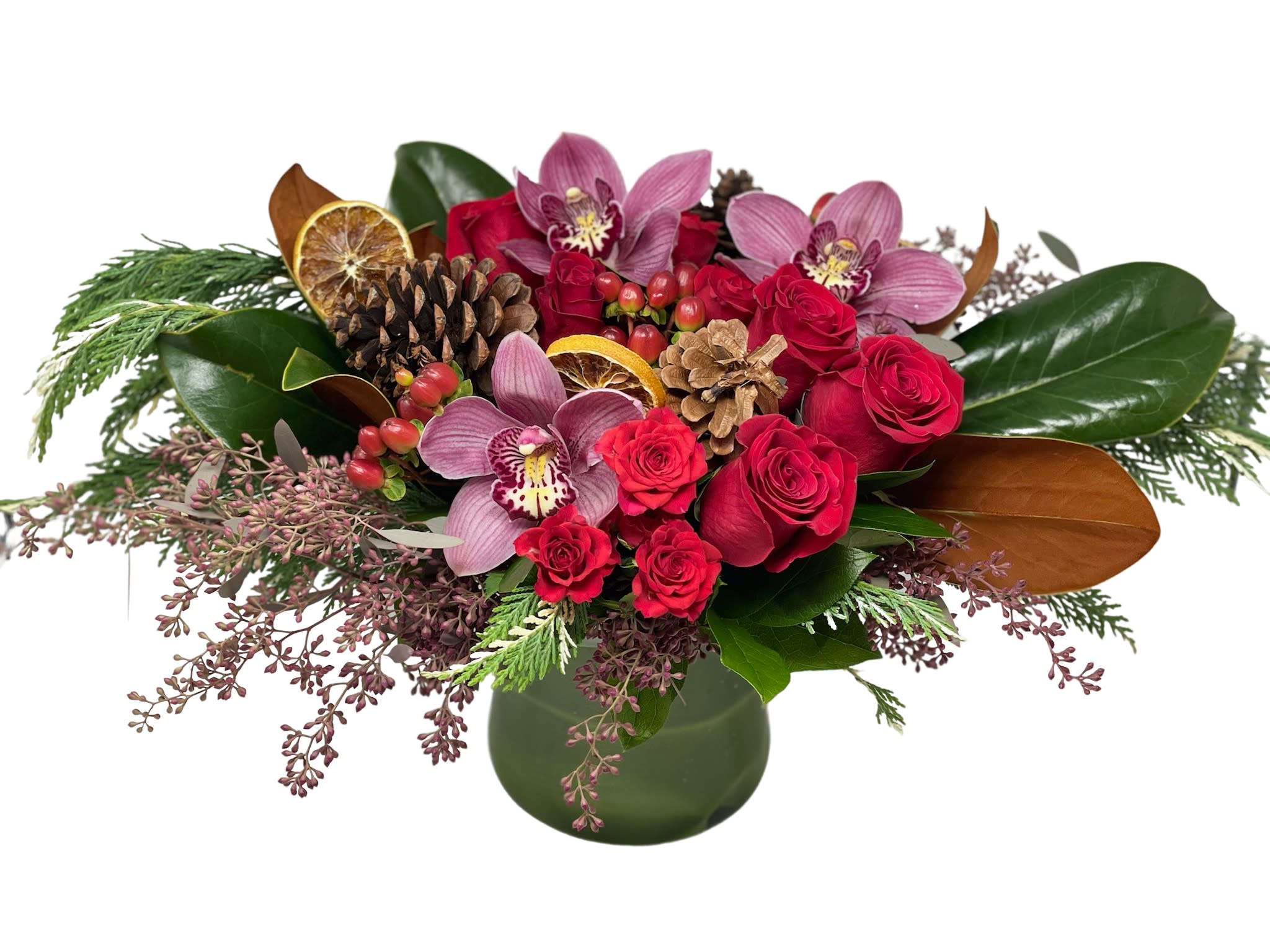 Noel Centerpiece  - Cymbidium Orchids, roses, magnolias, pinecone and orange slice decoration designed in a glass vase with Christmas greens. 