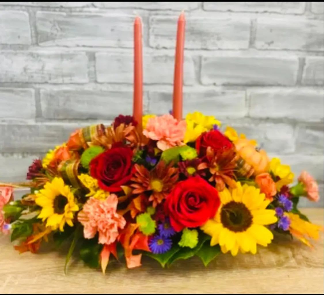 Thankgiving Centerpiece  - Centerpiece brings a touch of autumn elegance to any table setting.Featuring a vibrant mix of yellow lily, orange carnation, and  orange roses, this arrangement captures the essence of the season.