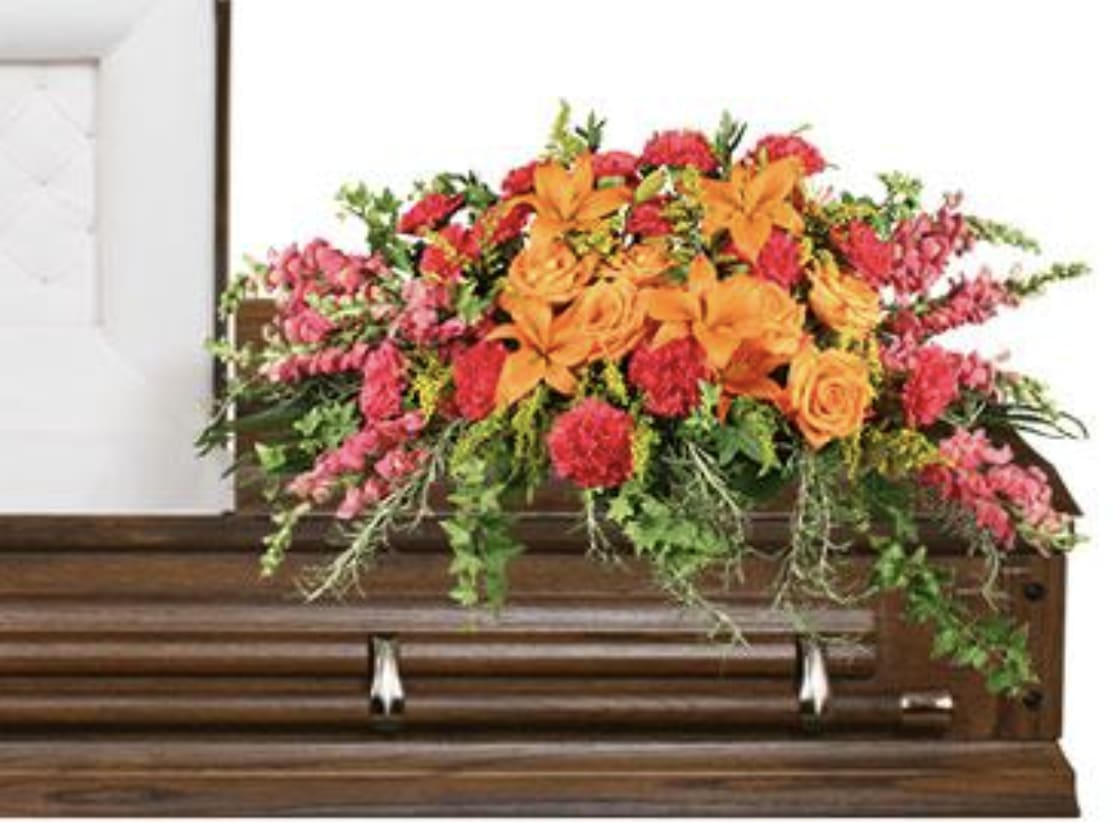 Tribute Casket Spray  - A vibrant display of orange and pink flowers arranged beautifully.   A unique arrangement hand created by our experienced designers. Please note that every design is custom made and substitution to container and flower types may happen from time to time. Design aspects will always stay the same, but if needed, we will substitute with flowers of equal or greater value to offer you a great floral shopping experience! Our flowers are 100% guaranteed. Please call us with any questions or concerns.