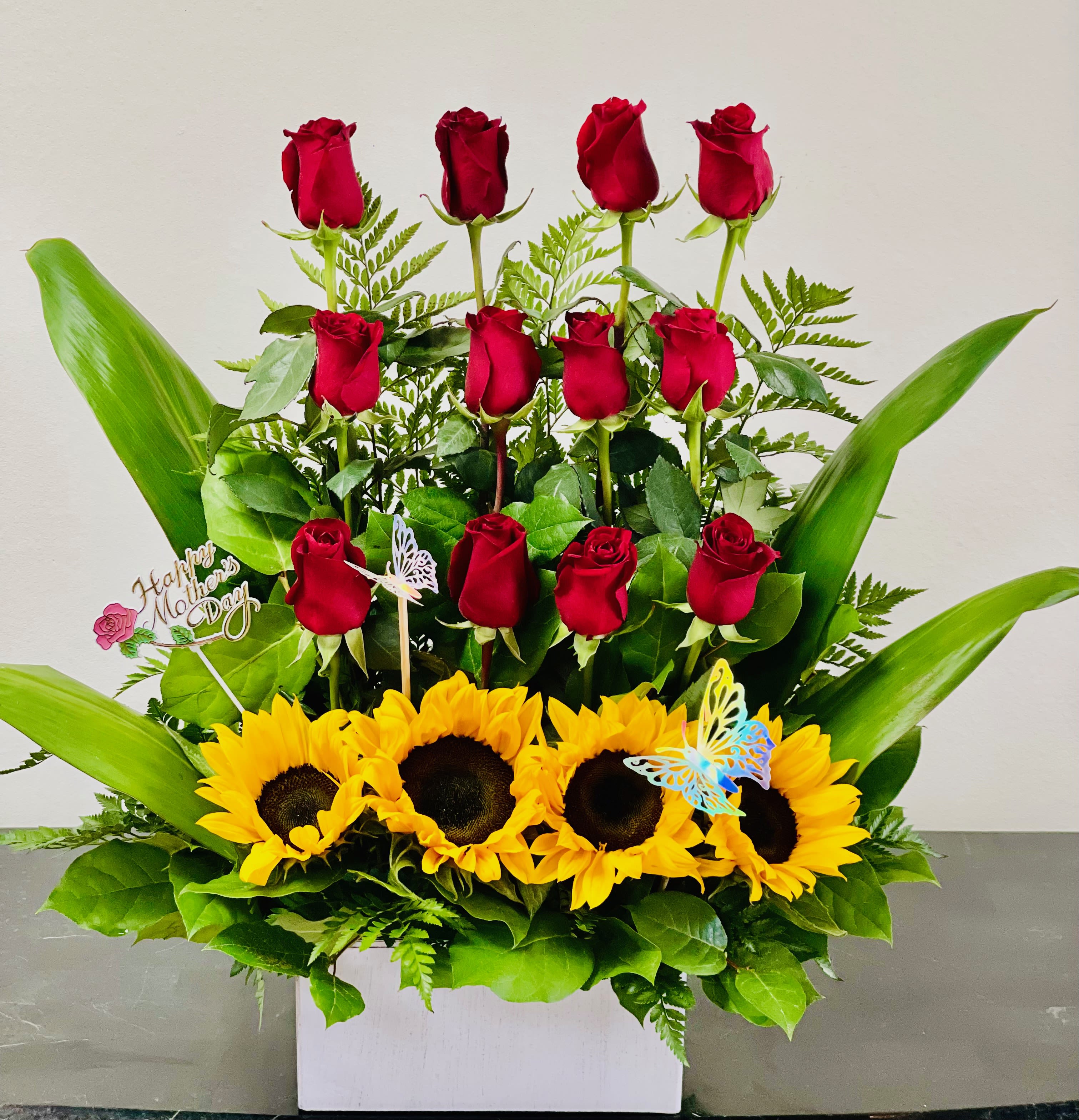 BF-M6 Mother's Day Rustic Radiance - Celebrate a special day with our stunning arrangement featuring a dozen premium red roses adorned with cheerful sunflowers, presented in a charming wood square container.