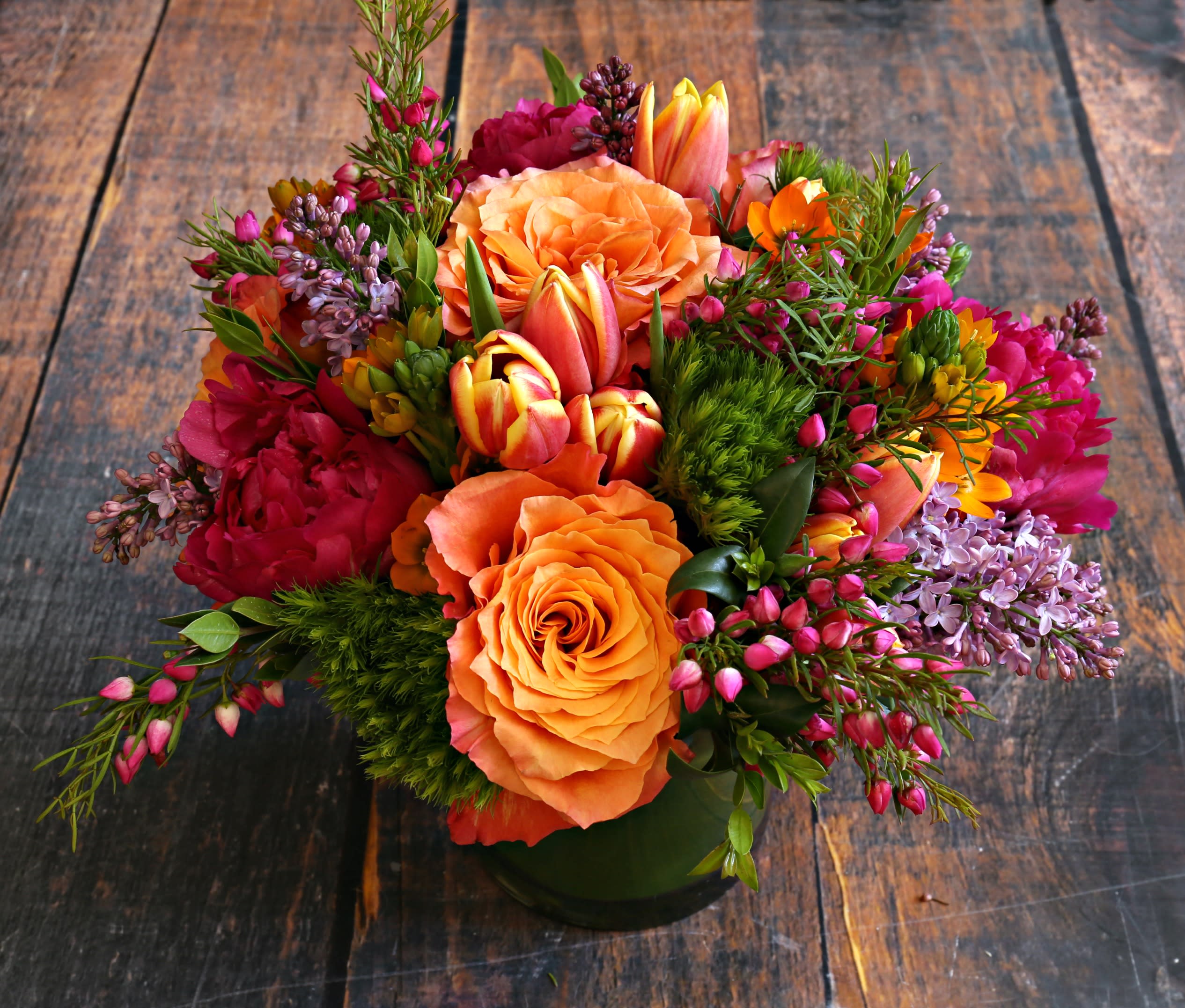 Sunset Bouquet - Sunshine in a vase! This beautiful, warm-toned, orange, and yellow arrangement will be sure to put a smile on someones face! as the season progresses some flower go out of season, we will substitute with appropriate flowers.
