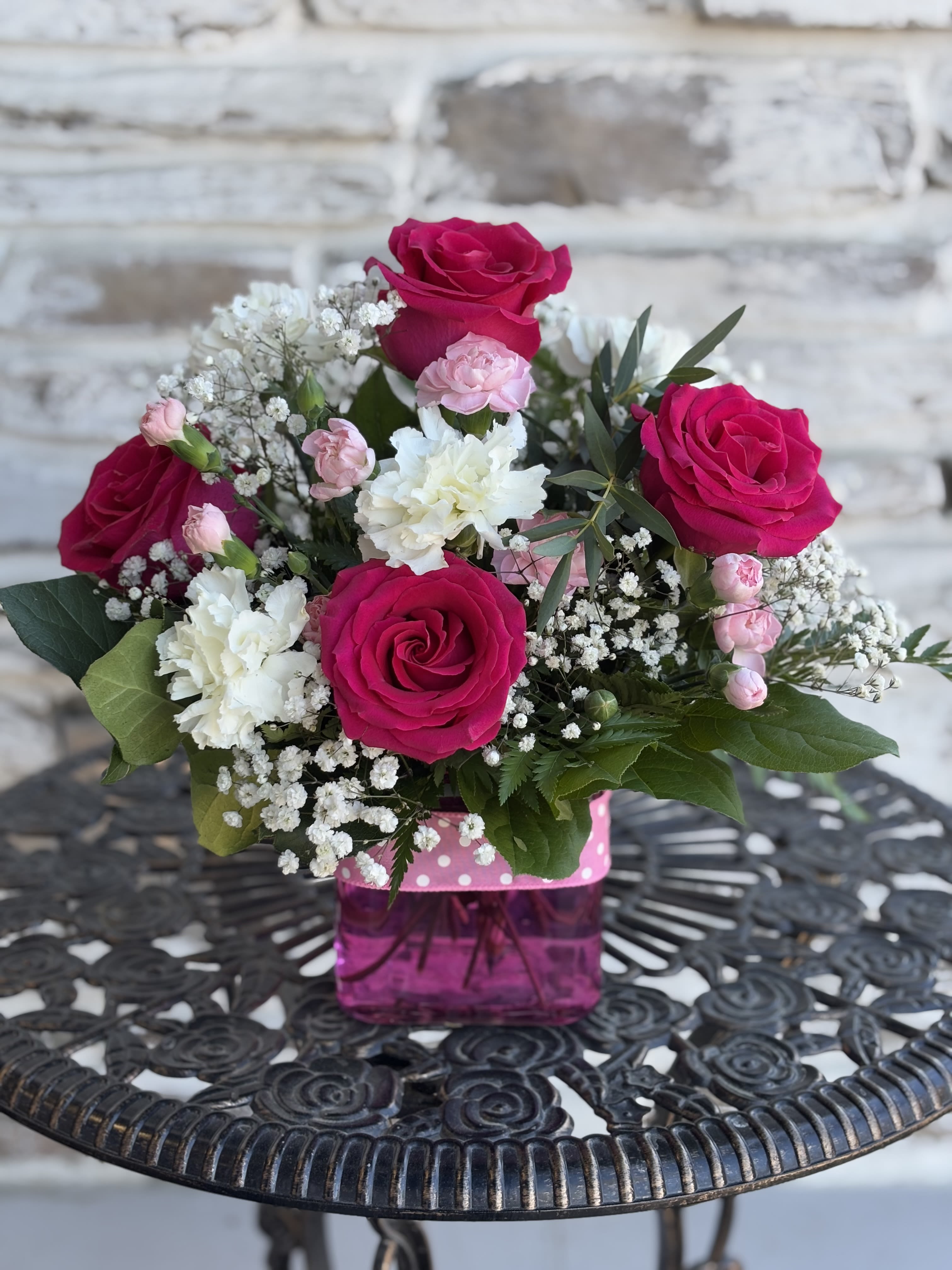 Polka Dot Pink - This beautiful bouquet features pink roses with pink and white carnations arranged in a gorgeous pink cube wrapped with a pink ribbon. Send this bouquet as a thoughtful gift.