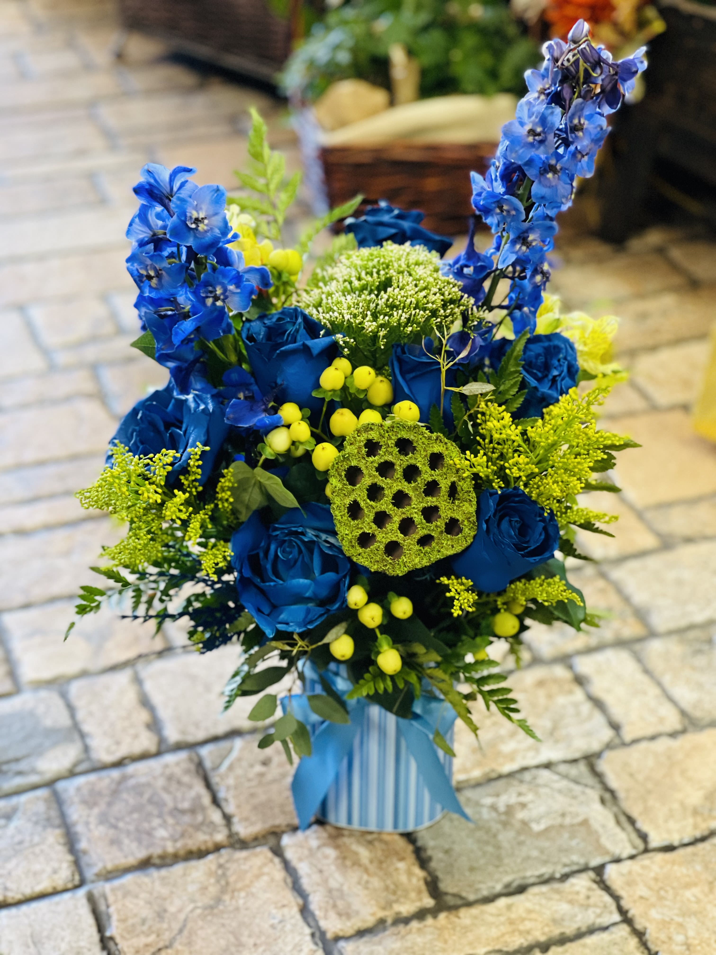 Enchanted navy - Bold, elegant, and beautifully unique, Enchanted Navy blends deep navy hues with lush green blooms for a striking, modern arrangement. Rich tones create a sense of mystery and sophistication, while fresh greenery adds balance and natural charm. Perfect for making a refined statement, this arrangement brings depth, style, and a touch of enchantment to any room or occasion.