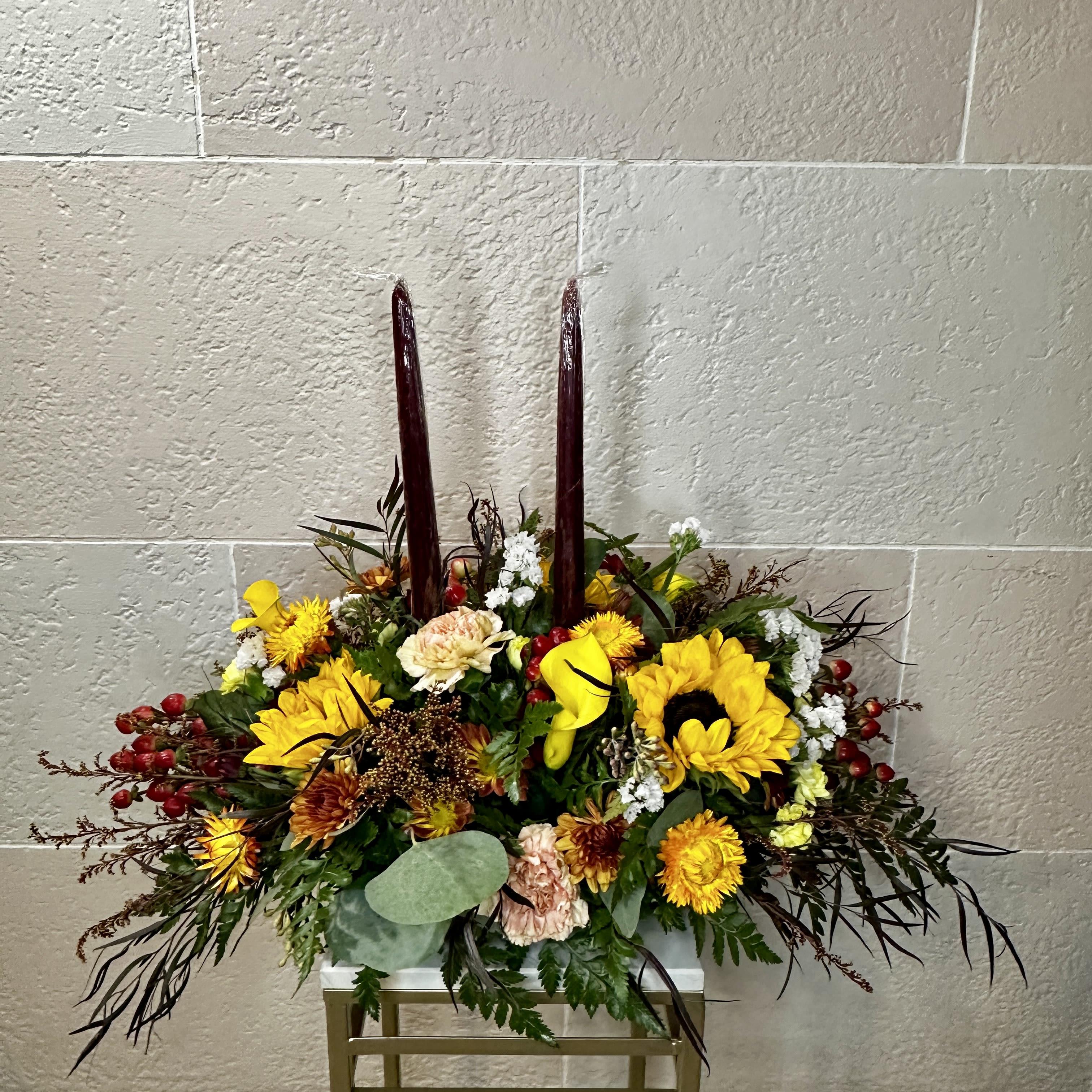 2 Candle Thanksgiving Centerpiece - A low laying thanksgiving centerpiece full of a mixture of fall colors and flowers. Paired with two candle sticks to match in the center of the arrangement.  **Colors &amp; flowers may vary depending on shop availability**