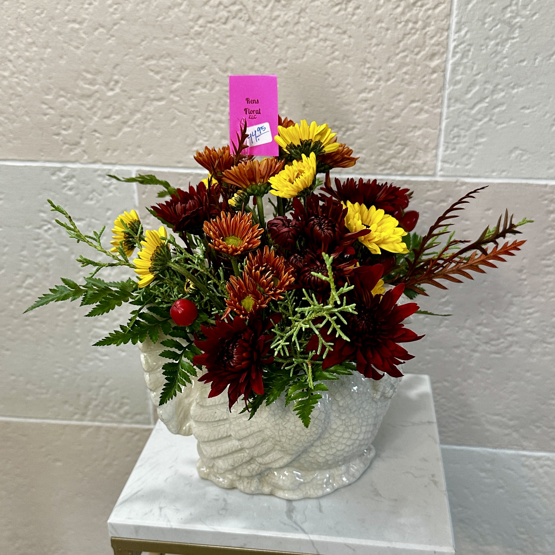 Turkey Day Centerpiece - A white ceramic turkey container with a mixture of longer lasting flowers.   **Flowers and colors may very depending on shop availability**