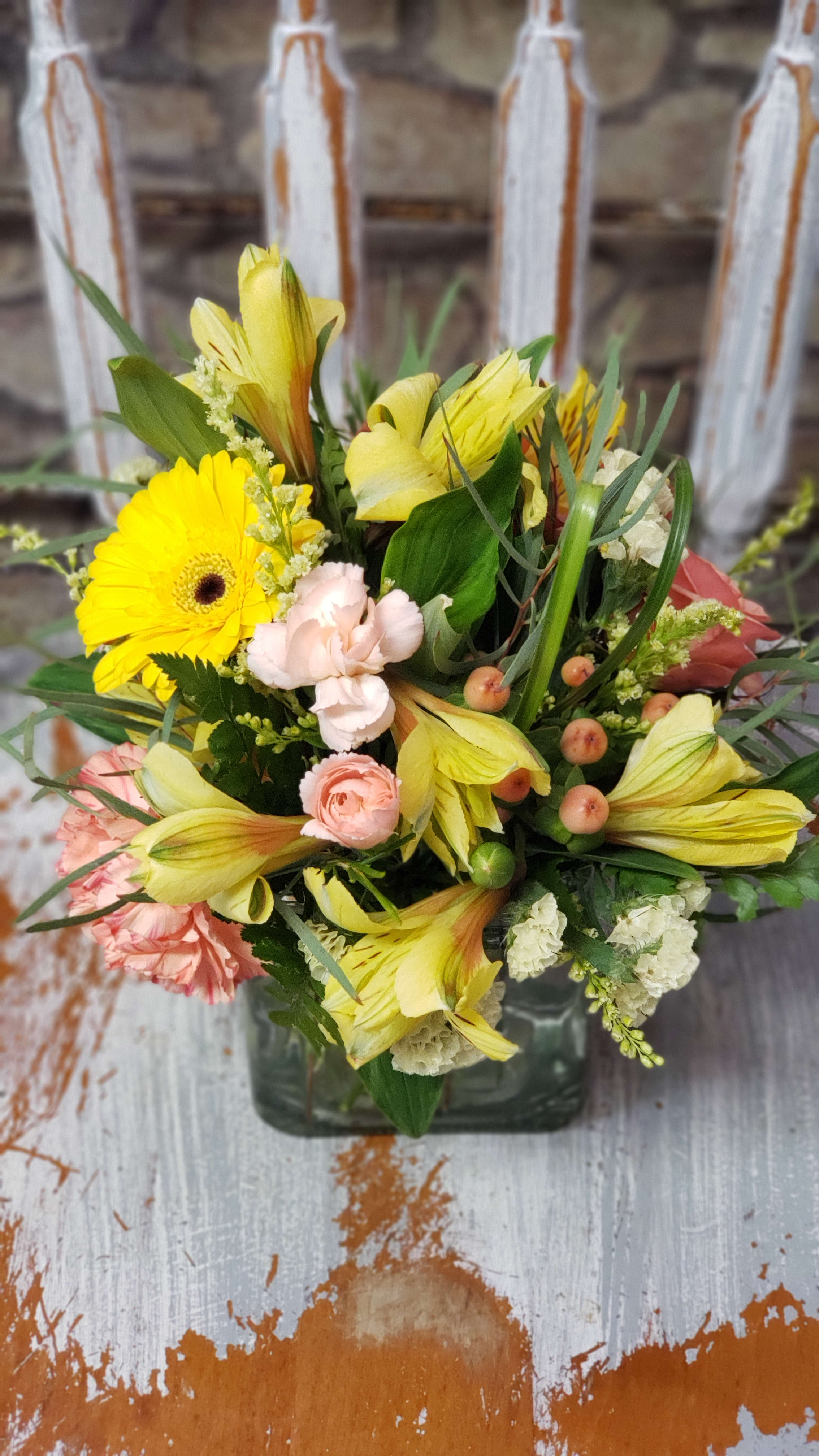 Sweet Sunshine  - Sweet 4x4 cube of sunny colors to brighten ones space or day!  Variety of flowers can be chosen by the designer based on market fresh inventory at time of order &amp; delivery.  Deluxe has the Spray rose stem or standard rose for an added touch!  Premium will be in a 4.75 cube with more florals.  Flowers &amp; color of flowers could vary at times.  