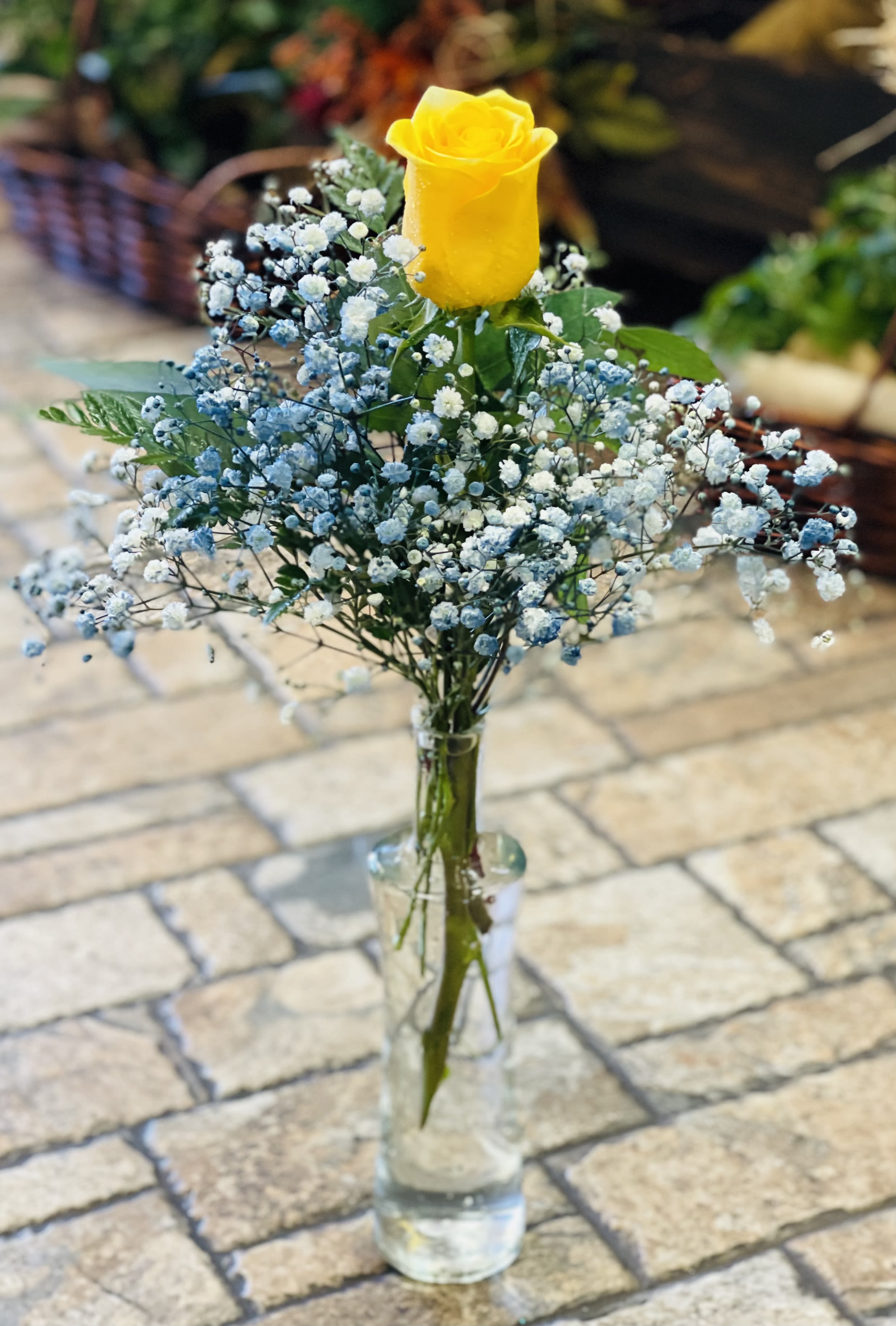 Blue horizon rose  - In store pick up only!  Blue Horizon Rose Bright, uplifting, and wonderfully unique, Blue Horizon Rose features a single yellow rose symbolizing warmth and joy, paired with airy blue baby’s breath for a dreamy, sky-inspired touch. Presented in a simple vase, this petite arrangement captures the feeling of sunshine meeting a clear blue horizon. Perfect for birthdays, congratulations, or any moment that calls for a burst of cheerful elegance.