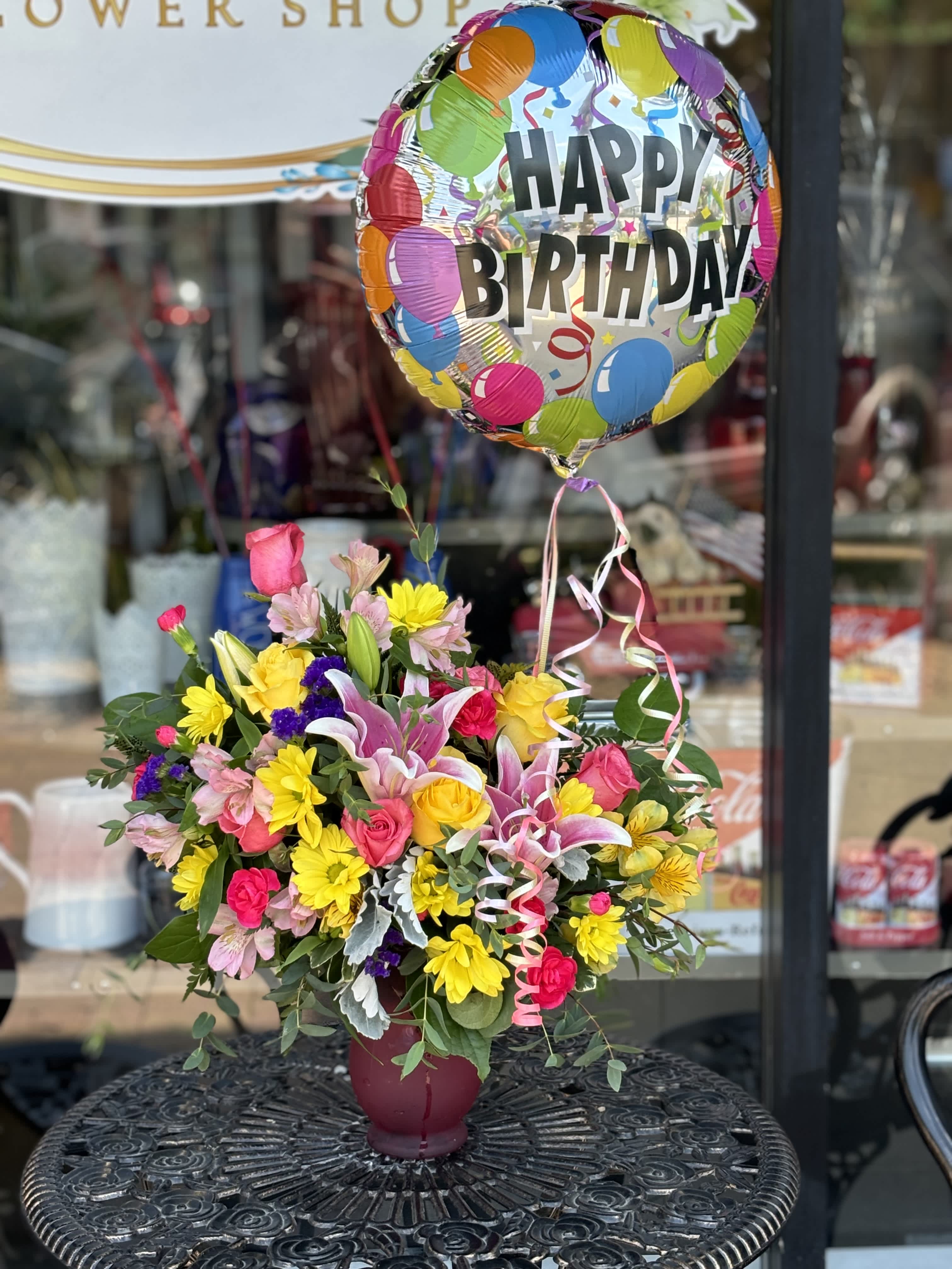 Birthday Surprise  - Surprise your special person with this burst of blooms and a Happy Birthday balloon! This bouquet includes hot pink and yellow roses, lilies, alstroemeria, miniature carnations, and chrysanthemums in a pink vase. 