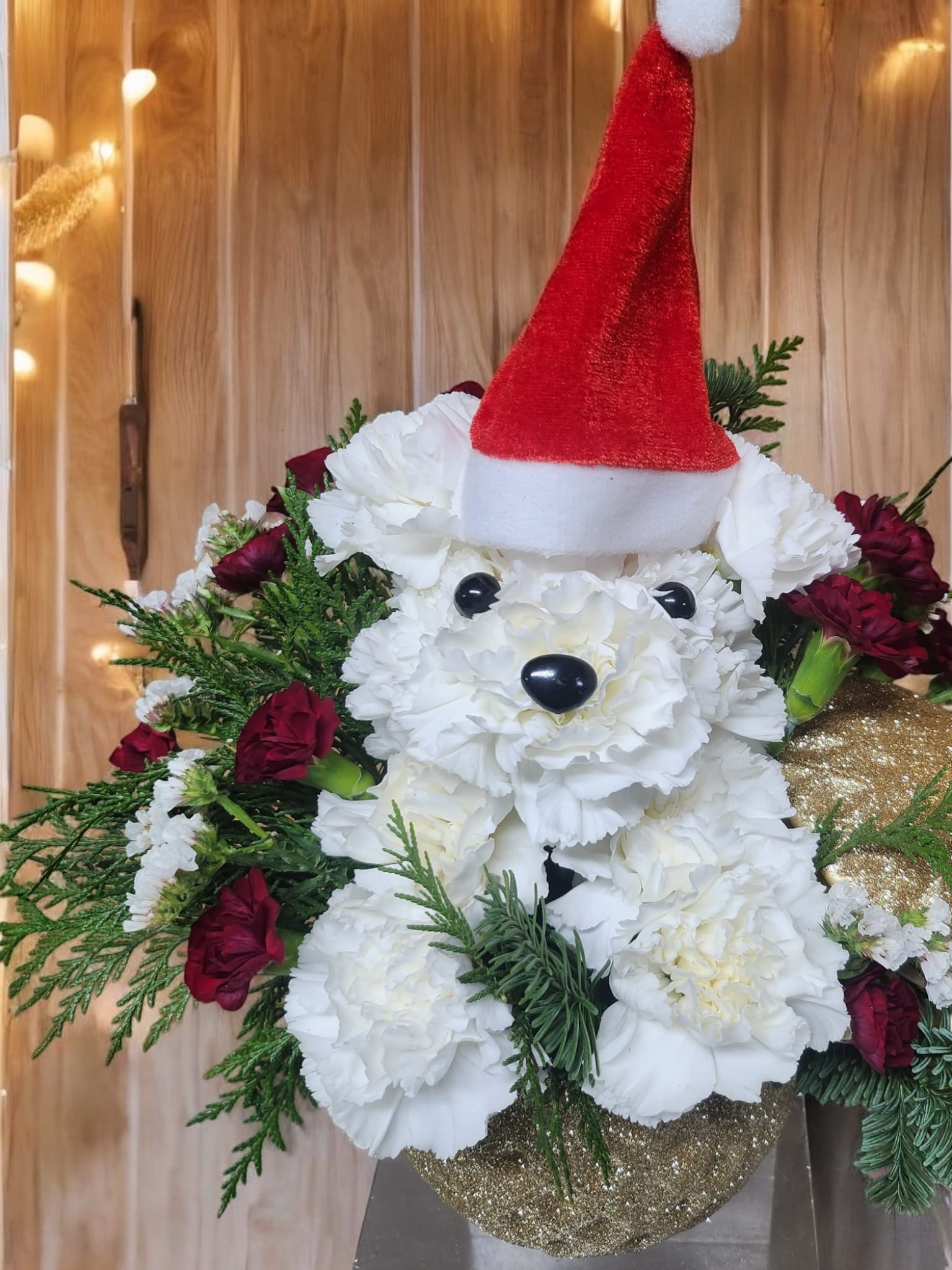 Dog in gold - Dog in a gold ornament with a red hat made with  carnations 