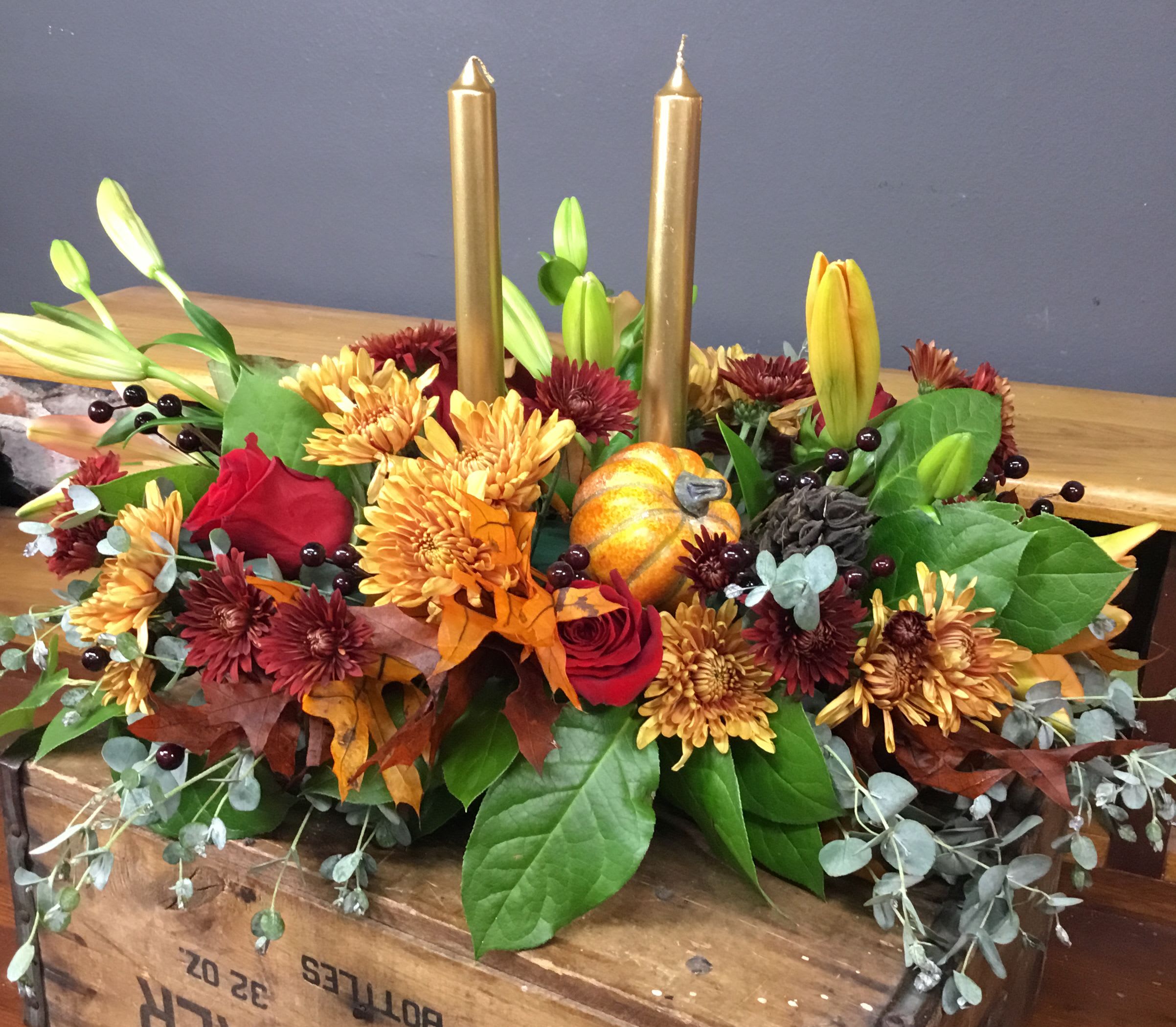 2 candle Thanksgiving Centerpiece - 2 candle Thanksgiving Centerpiece, with assorted fall greens and flowers. Color of candles my vary