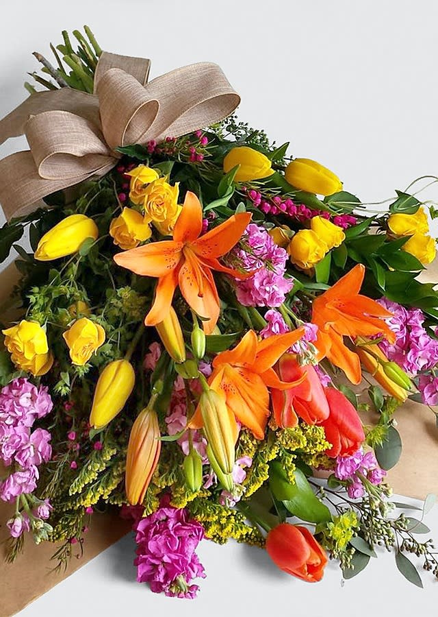 Truly Tropical Wrapped Bouquet - Truly Tropical Wrapped Bouquet includes bright and vibrant tropical flowers including lilies, roses, tulips and other fresh flowers.  Our loose bunches are designed with fresh flowers, individually created by our designers, wrapped, and finished with a lovely bow. These bouquets will vary daily based off of the best seasonal selection.  Our loose bunches do NOT include vases. Paper and bow color will vary.