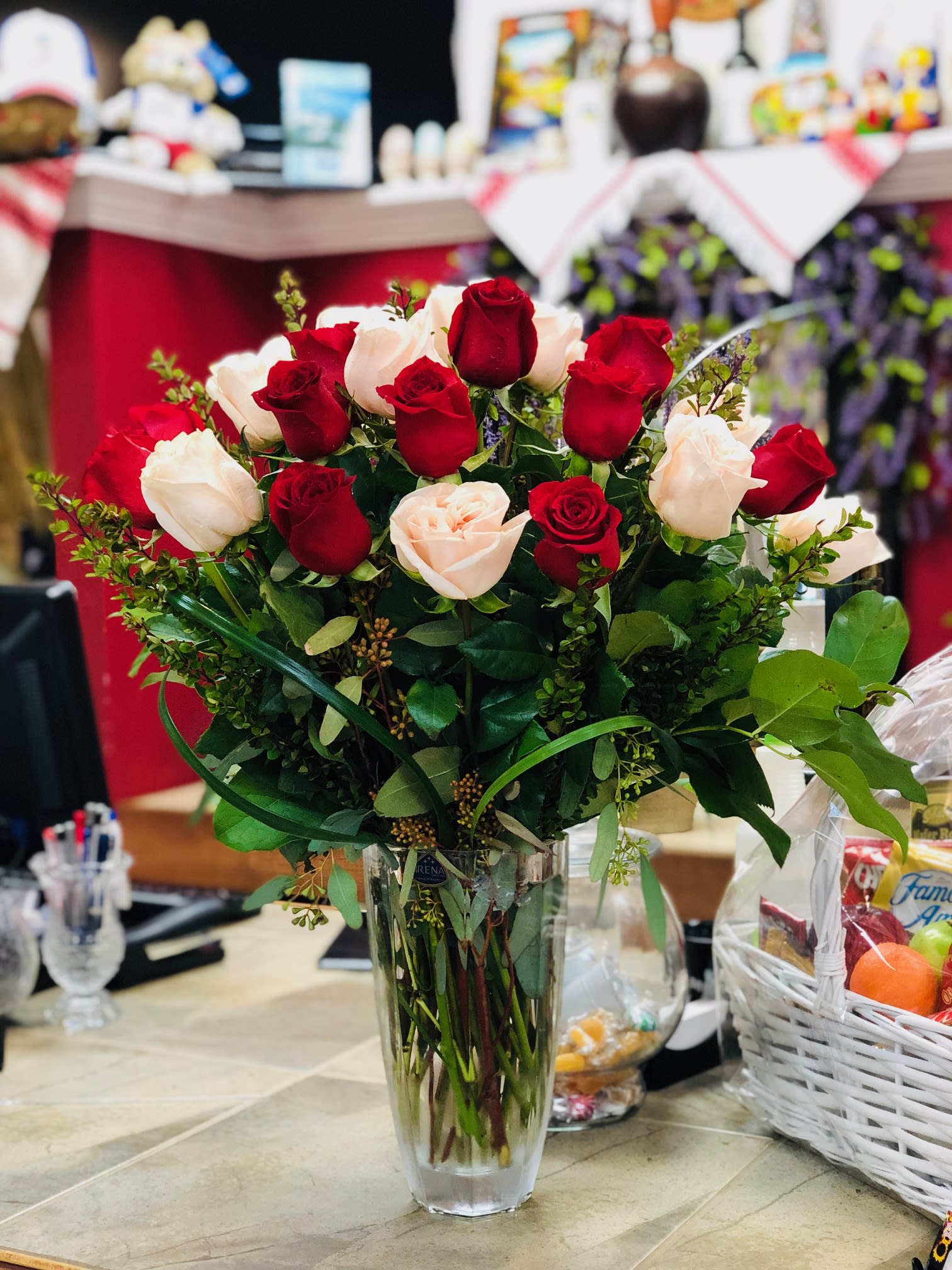 In Love  - Love is in the air with this big bouquet of 24 lush red and white garden roses with lavish greens guaranteed to take anyone's breath away. With it's grace, it's an unforgettable symbol of your love.