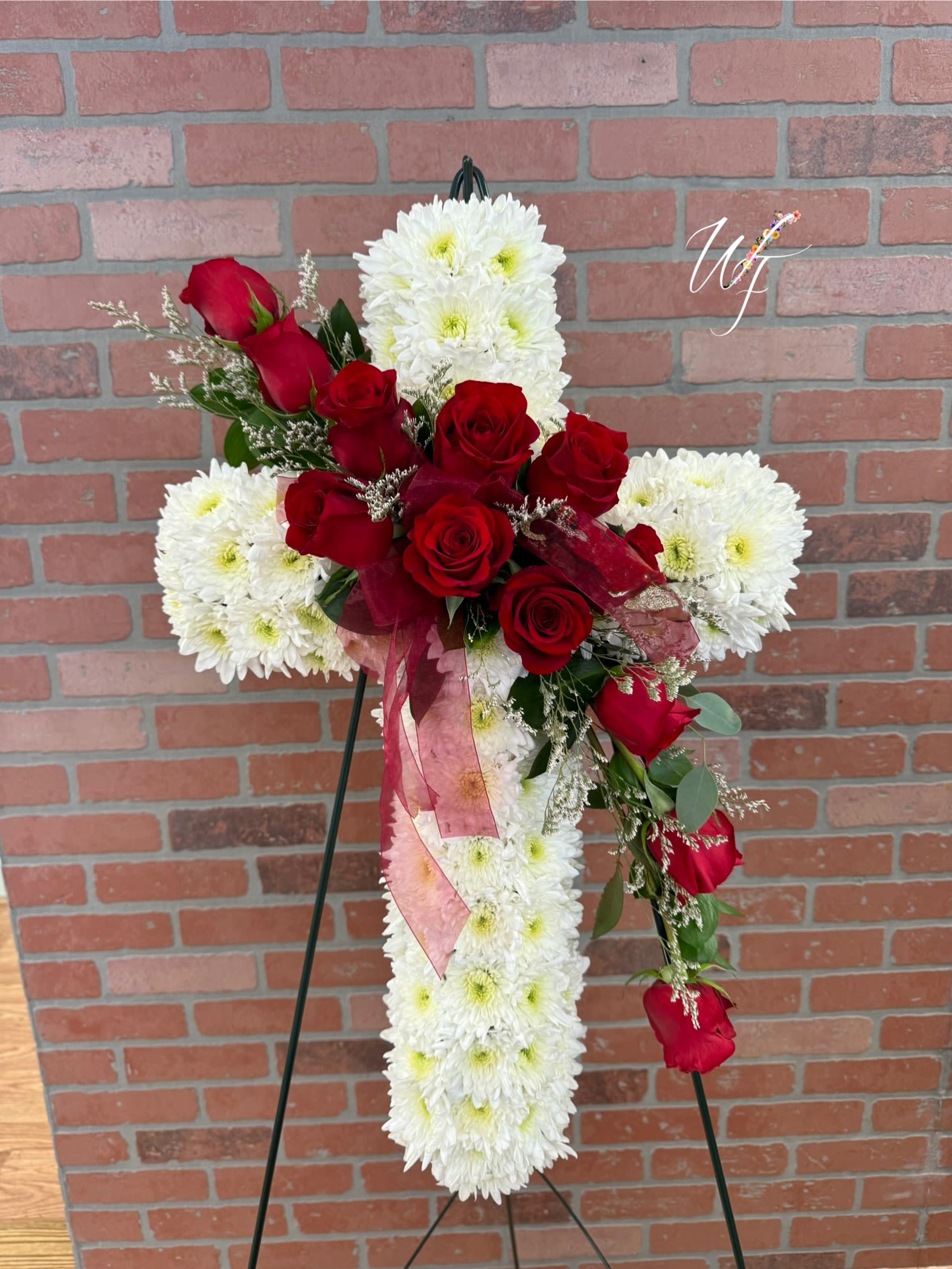 Faithful Wish - White cross adorned with red roses and greenery 