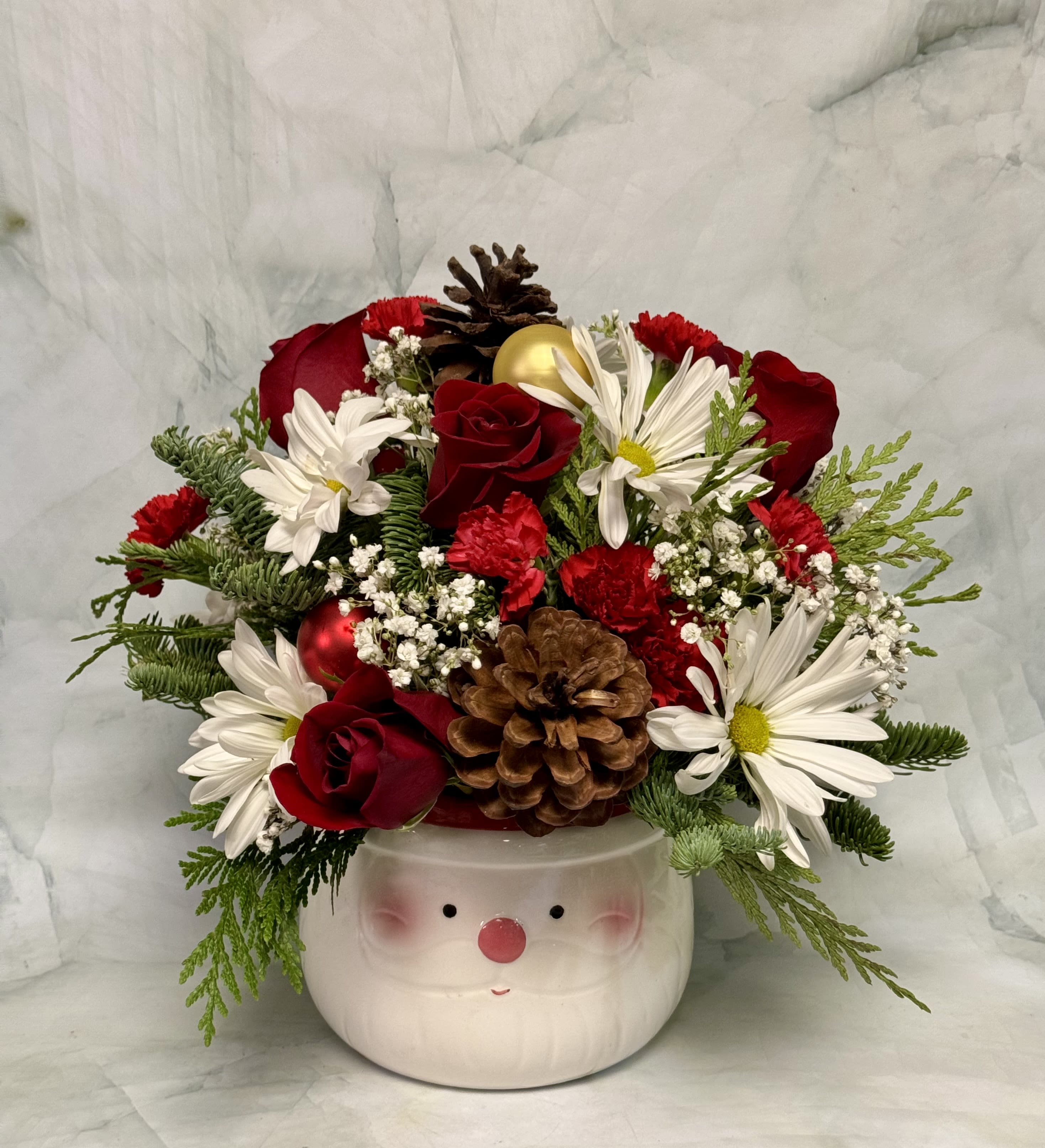 Here Comes Santa Claus!  - SANTA! Santa is here and better than ever. Now, he is available in this adorable ceramic planter container that can be used to create one of our most incredible holiday designs yet! Red roses, daisies, mini carnations, babies breath, pine cones, winter greens and holiday ornaments are all included in this floral arrangement. 