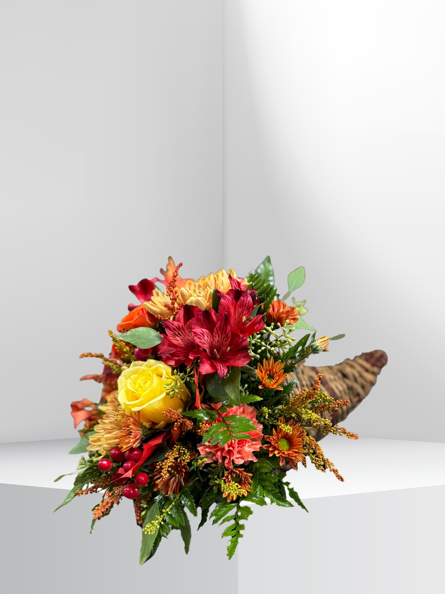 Harvest Harmony Cornucopia  - A beautiful cornucopia filled with a mix of seasonal blooms and foliage in warm autumn tones. Rich colors and textured greenery capture the essence of fall, making this arrangement a perfect centerpiece for Thanksgiving celebrations or cozy seasonal decor. 