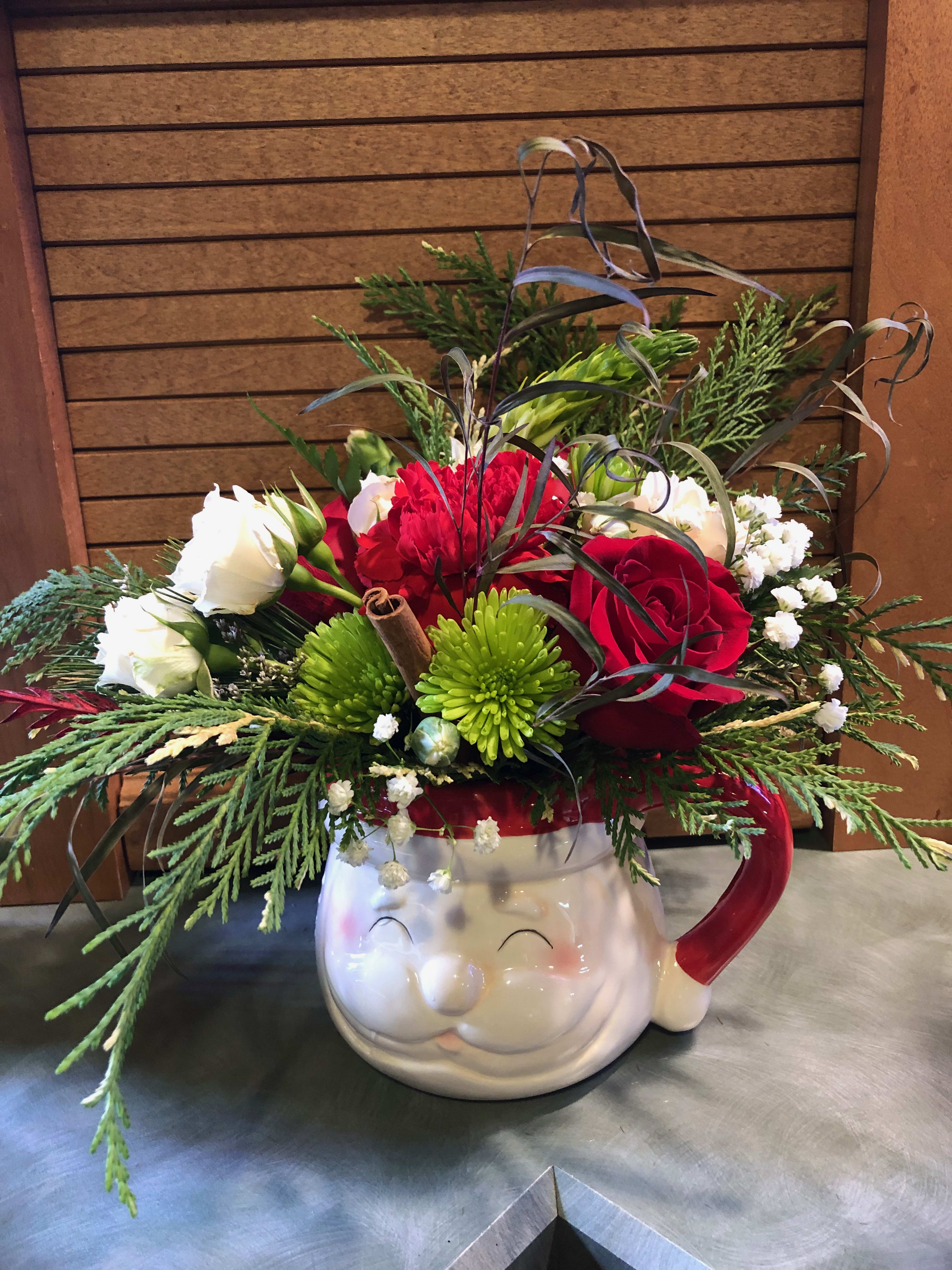 Hot Cocoa - Just the right size for a Hot cup of Cocoa, this favorite design is filled with Christmas cheer and a touch of spice. Fresh seasonal flowers are paired with seasonal greens in this reusable Santa mug. After the blooms have faded, hand wash the ceramic mug and use to sip your favorite hot beverage. Not for use in the microwave Inventory count: 1 remaining.