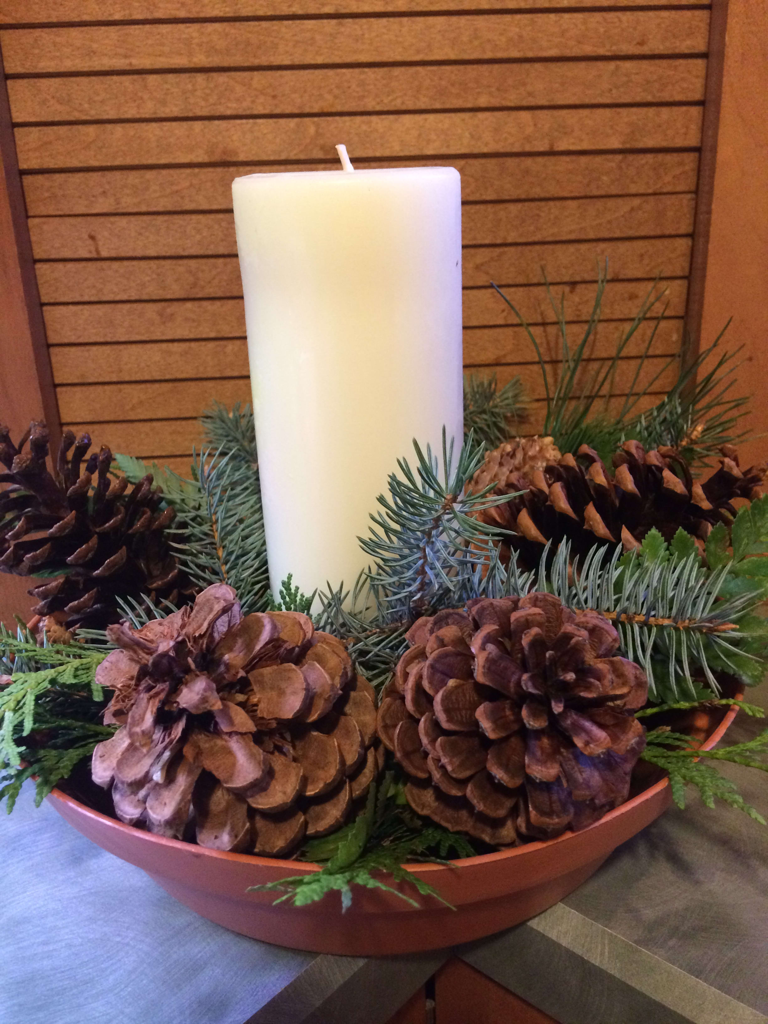 Pinecones &amp; Candle - Mixed pine &amp; cedar greens paired with 5 large pinecones and 1 large 8&quot; pillar candle inside a designer bowl. (Never leave lit candle unattended. Keep out of reach of pets and small children.)