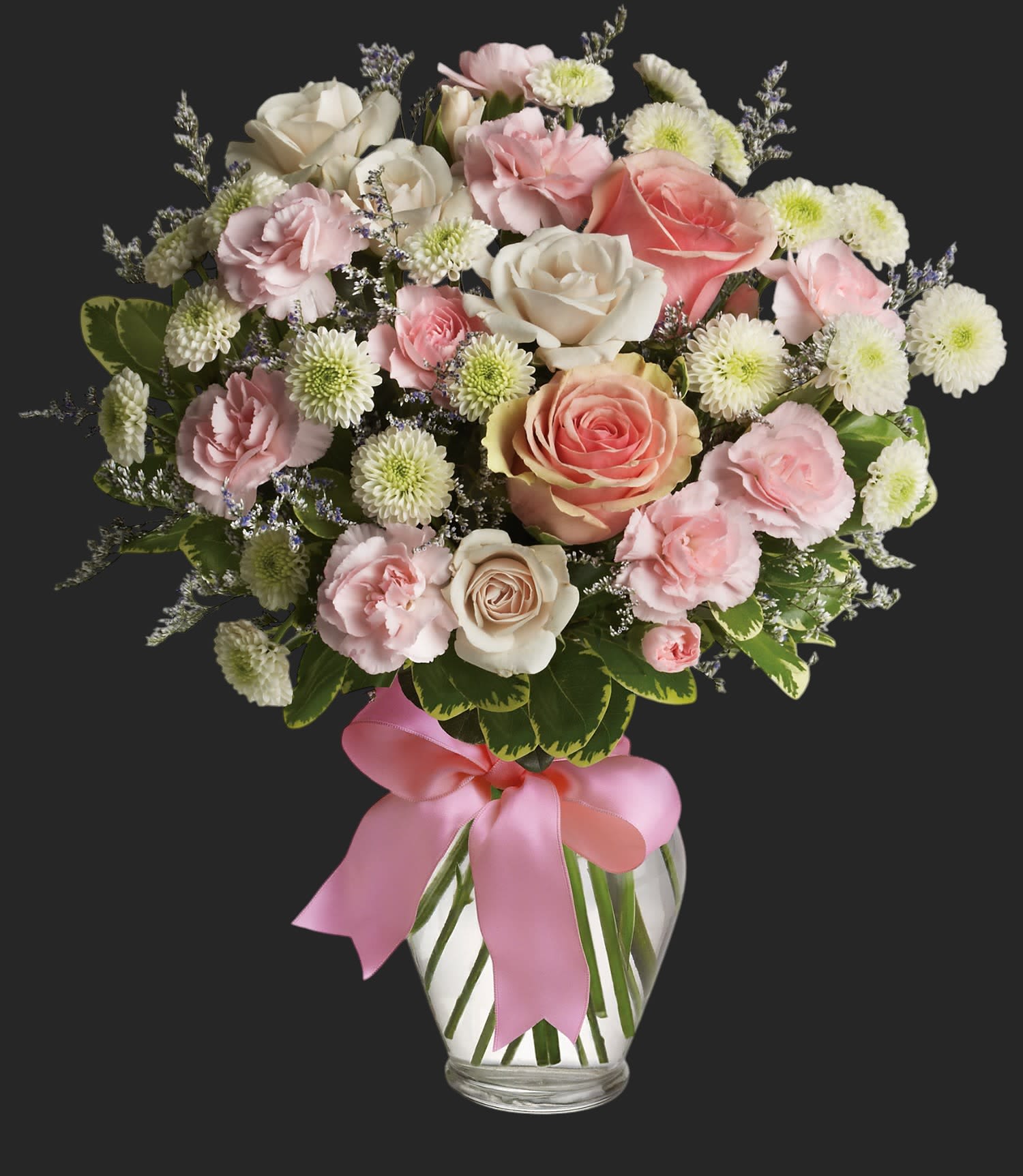 Cotton Candy - Pretty pink roses, spray roses and miniature carnations, white button spray chrysanthemums, lavender limonium and green pittosporum fill a spring glass vase that's wrapped with a pink satin ribbon. It's confection perfection! Approximately 13&quot; W x 14 1/2&quot; H    T37-1A