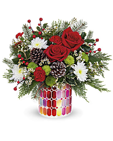 Teleflora's Merriest Season Bouquet - The Merriest Season is here! This festive red rose bouquet is sure to spread cheer in the Charming Mosaic cylinder. Later, it's lovely as a votive! Red roses, miniature red carnations, white cushion spray chrysanthemums, green button spray chrysanthemums, and white waxflowers arranged with cedar, noble fir, holly, white tipped pine cones, and berries. Hand-delivered in Teleflora's Charming Mosaic Cylinder. Orientation: All-Around