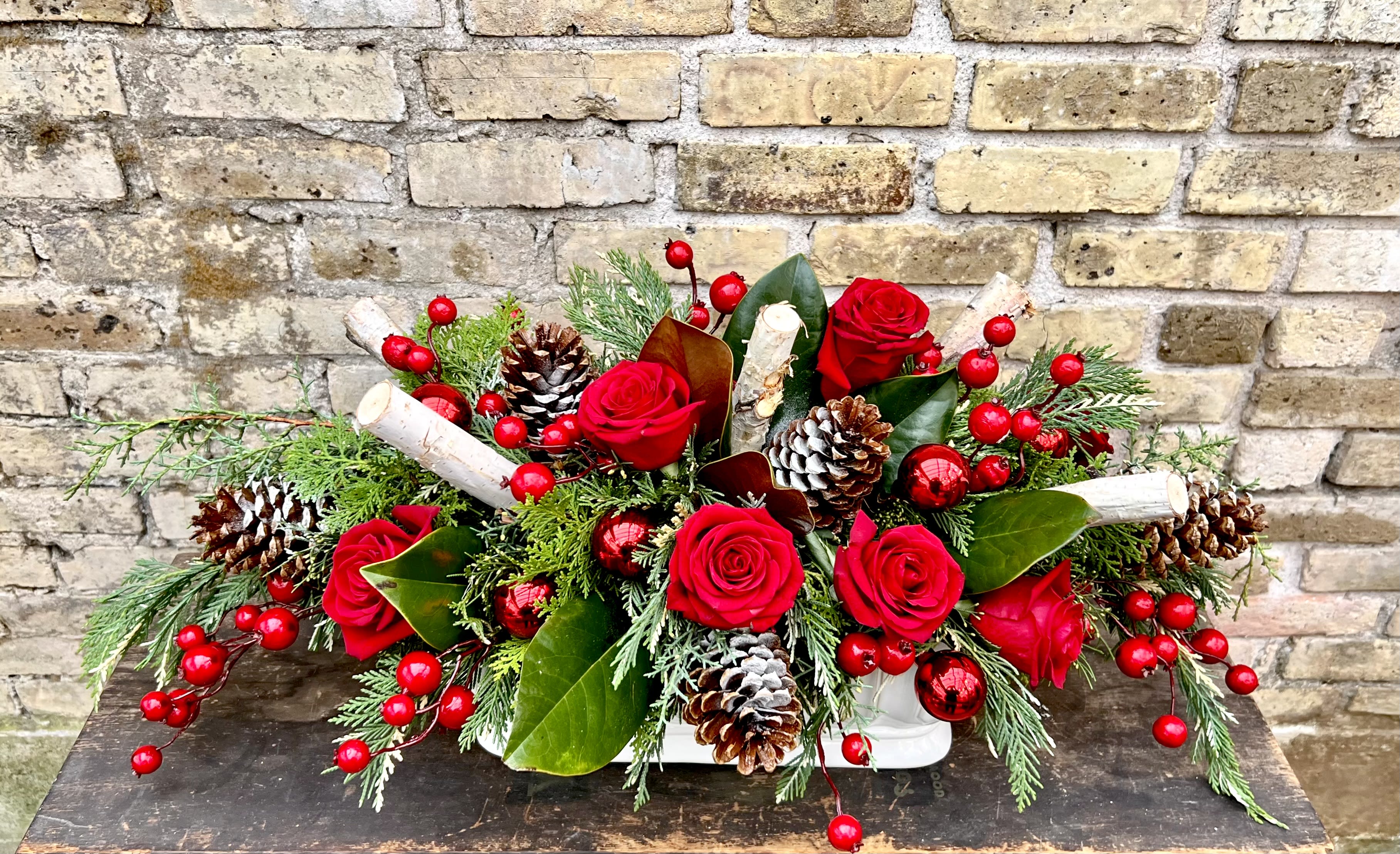 Polar Express - Make Your Holiday Table Look Fabulous ! Ceramic Container With an Assortment of Fresh Evergreens, Red Roses, Birch Logs, Ornaments, Red Berries and Pine Cones. 