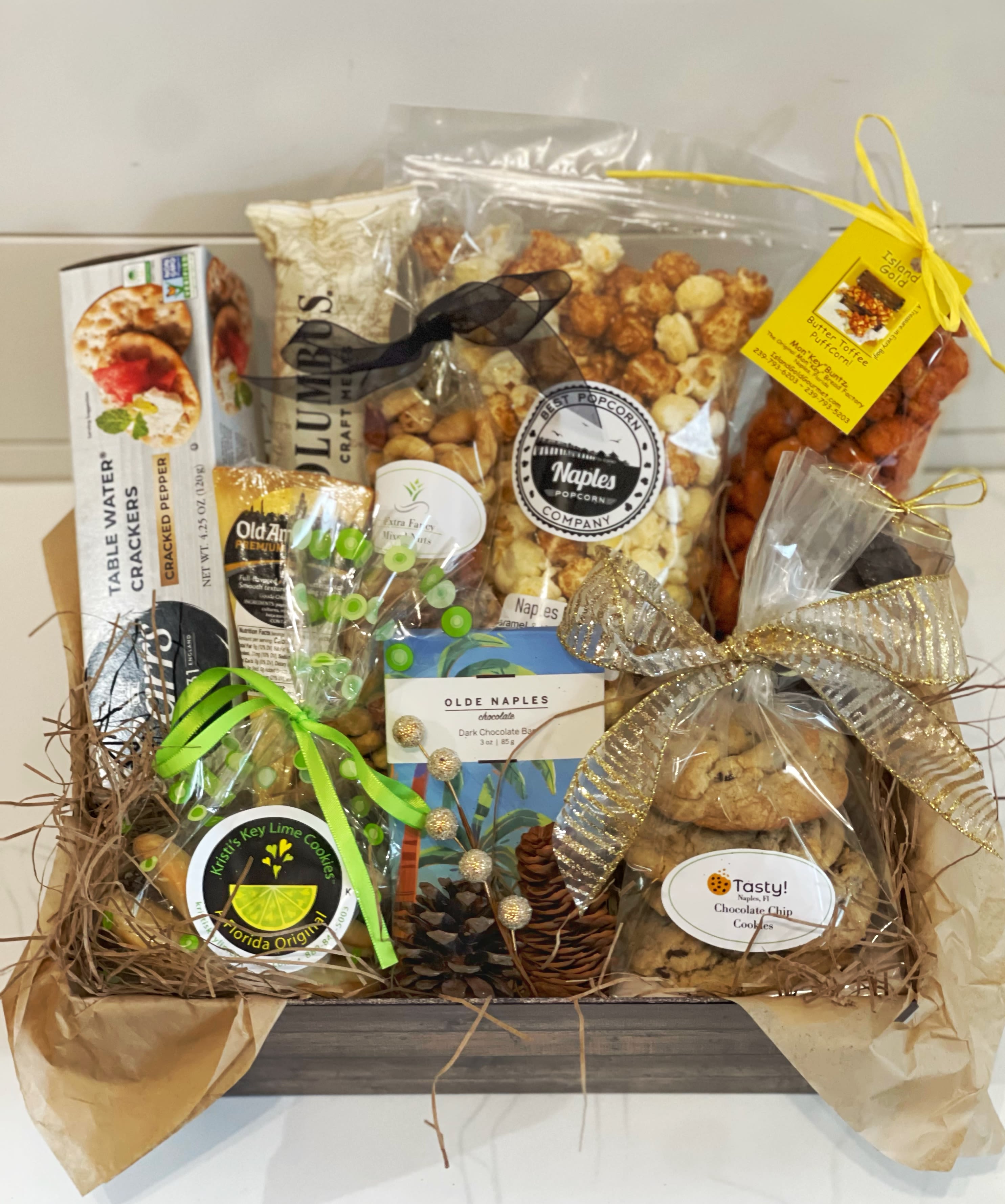 Local treats, deluxe basket (Christmas edition) - Gift something unique, full of local treats:  -Fresh chocolate chip cookies  -deluxe mixed nuts  -dark chocolate sea salt caramels  -Kristi’s key lime cookies  -Toffee Puffed Corn from Mon”key” Buntz @Tin City -Naples Mix Popcorn (white cheddar and caramel)  -Salami -Cheese -Crackers -Chocolate bar from Olde Naples Chocolates  Wrapped in cellophane and tied with a Christmas ribbon 