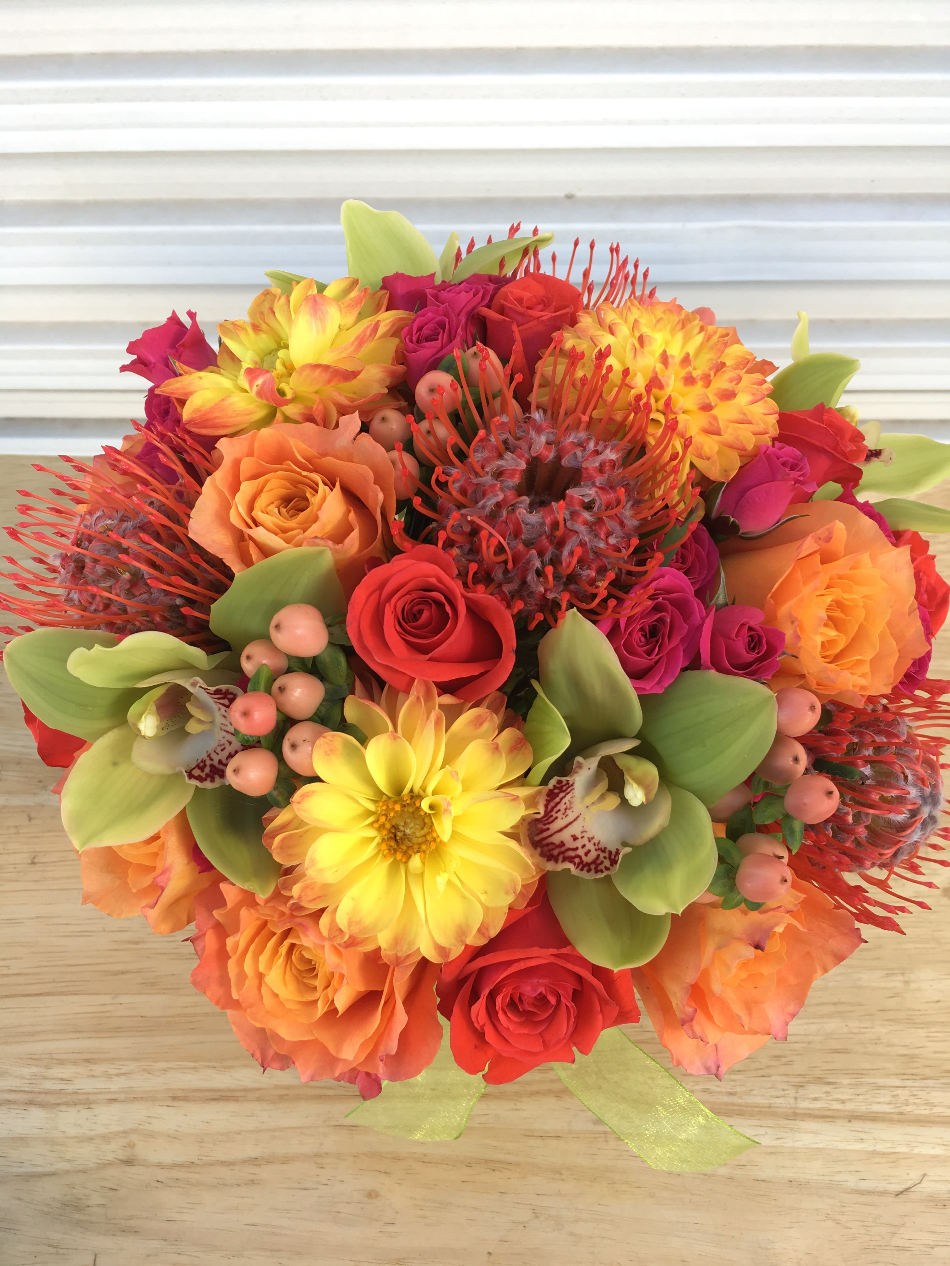 Scarlet Maple Arrangement - Vibrant and festive blooms in fall tones and textures.  Florals may include: roses, dahlias, orchids, pin cushion protea, brunia, hypericum berries, spray roses, and other seasonal premium blooms.  It's possible that some days we may not have the exact flowers depending on the season, or exact container specified on the arrangement's description. When this is the case, our bouquets are made with flower substitutions or delivered in a different vase than expected by using substitutions of an equal or higher value. If you'd prefer no substitutions, please send an email or call us after placing your order. Please give us at least three days notice if you're looking for an arrangement with no substitutions.